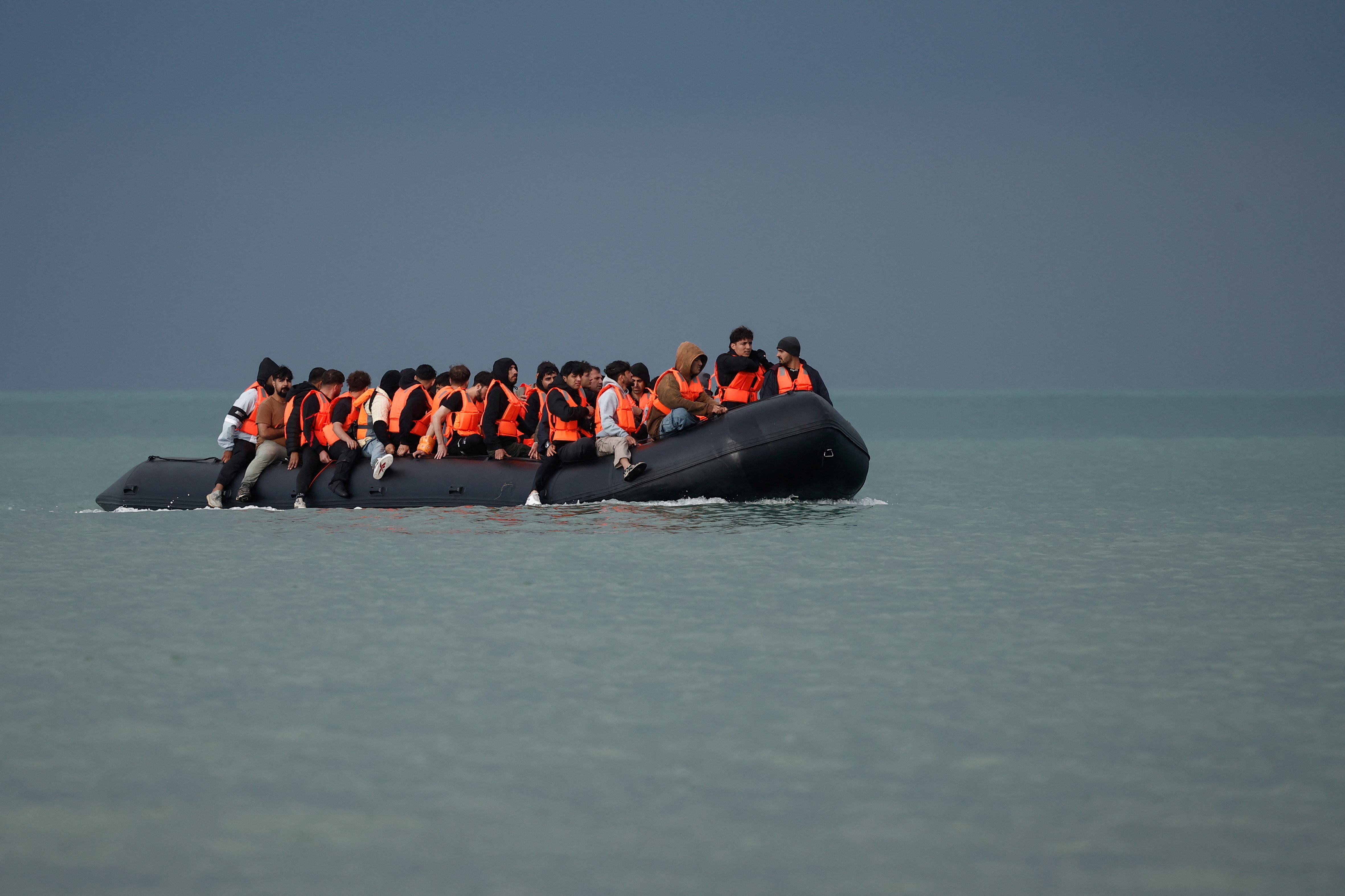 Migrants on an inflatable dinghy attempt to cross the English Channel to reach the UK.