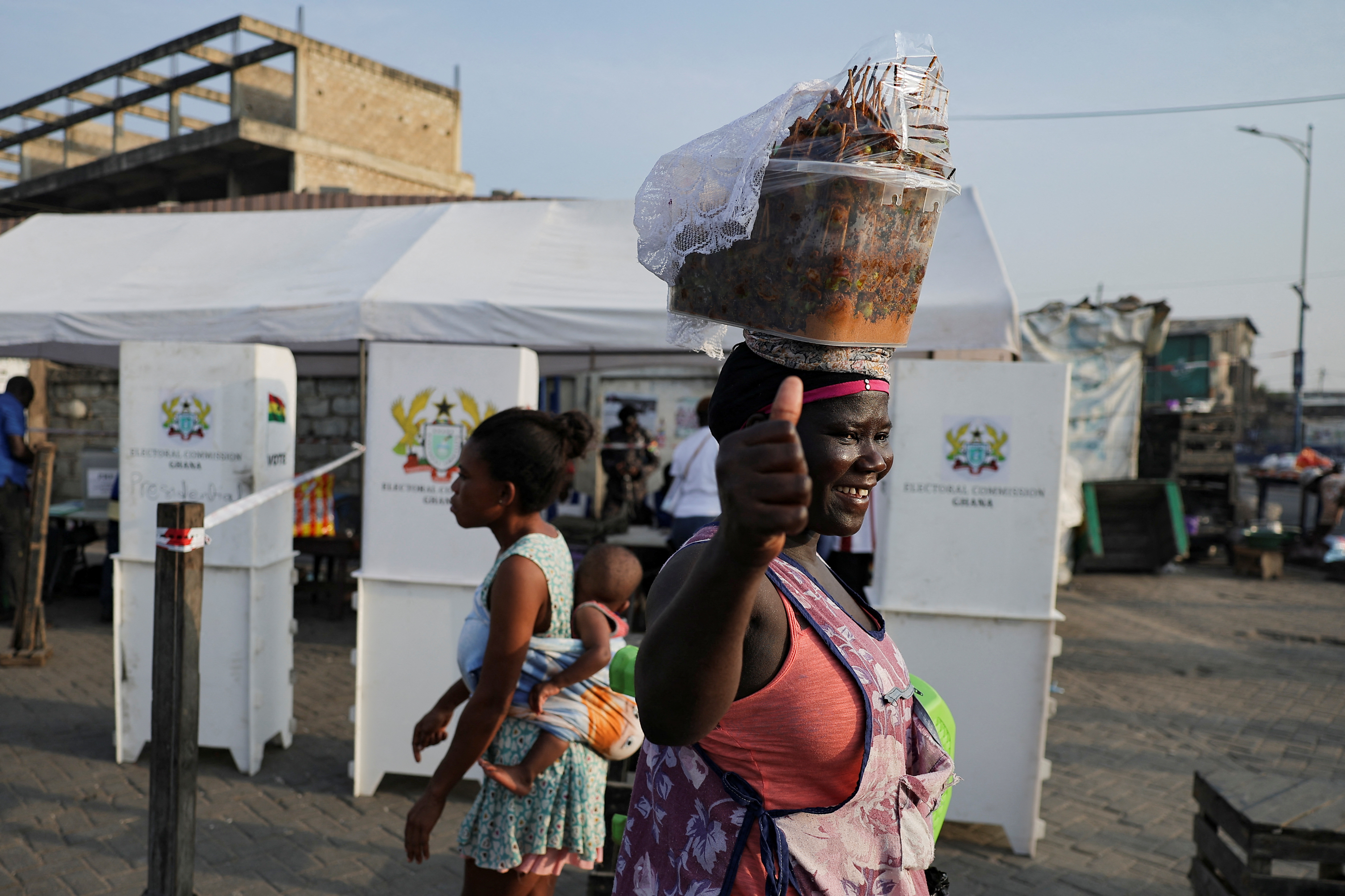 People walk past a polling station on the day of the presidential and parliamentary election in Jamestown, Accra, Ghana
