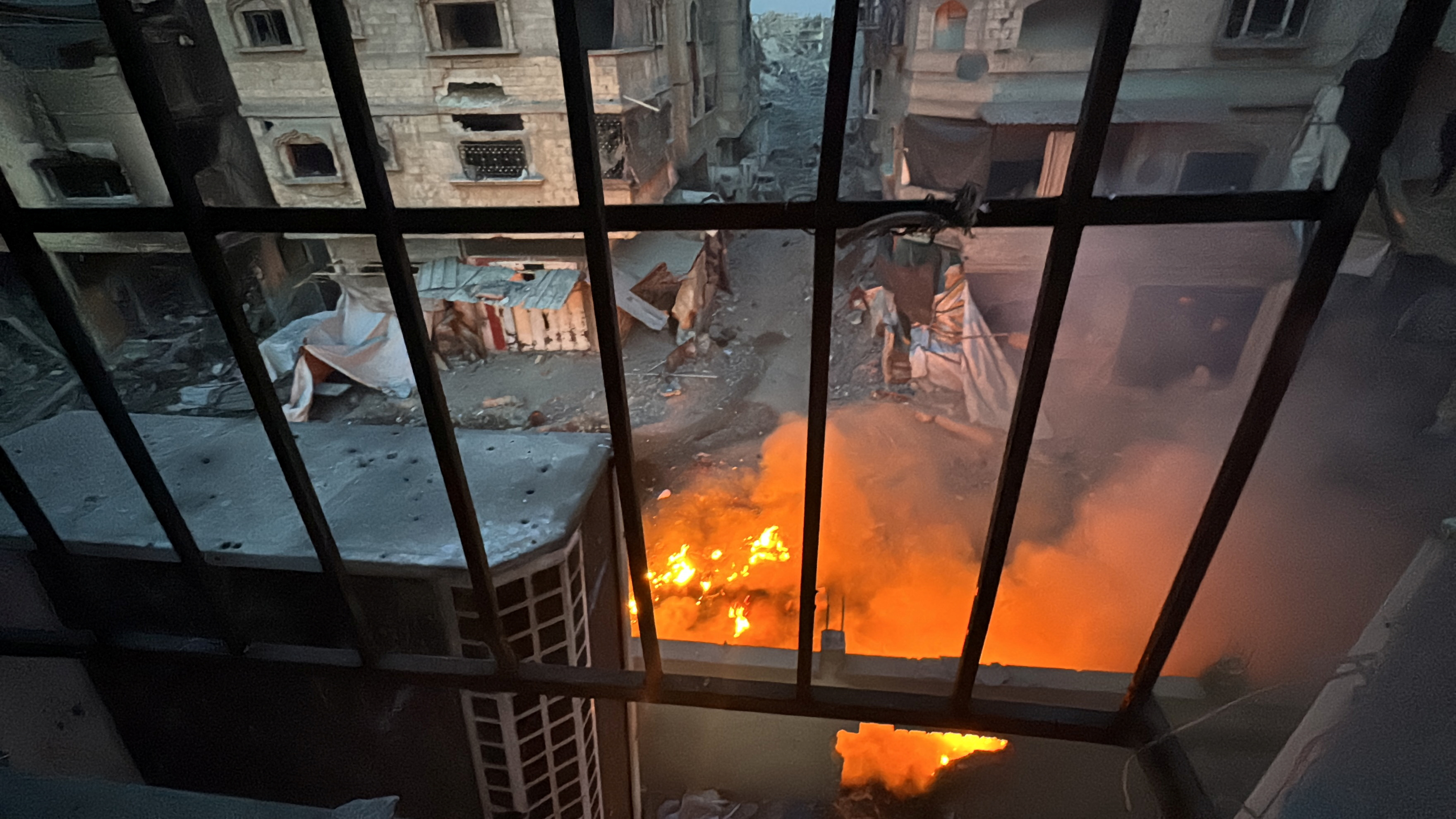 A fire burns as seen through a window from Kamal Adwan hospital, during the ongoing Israeli military operation