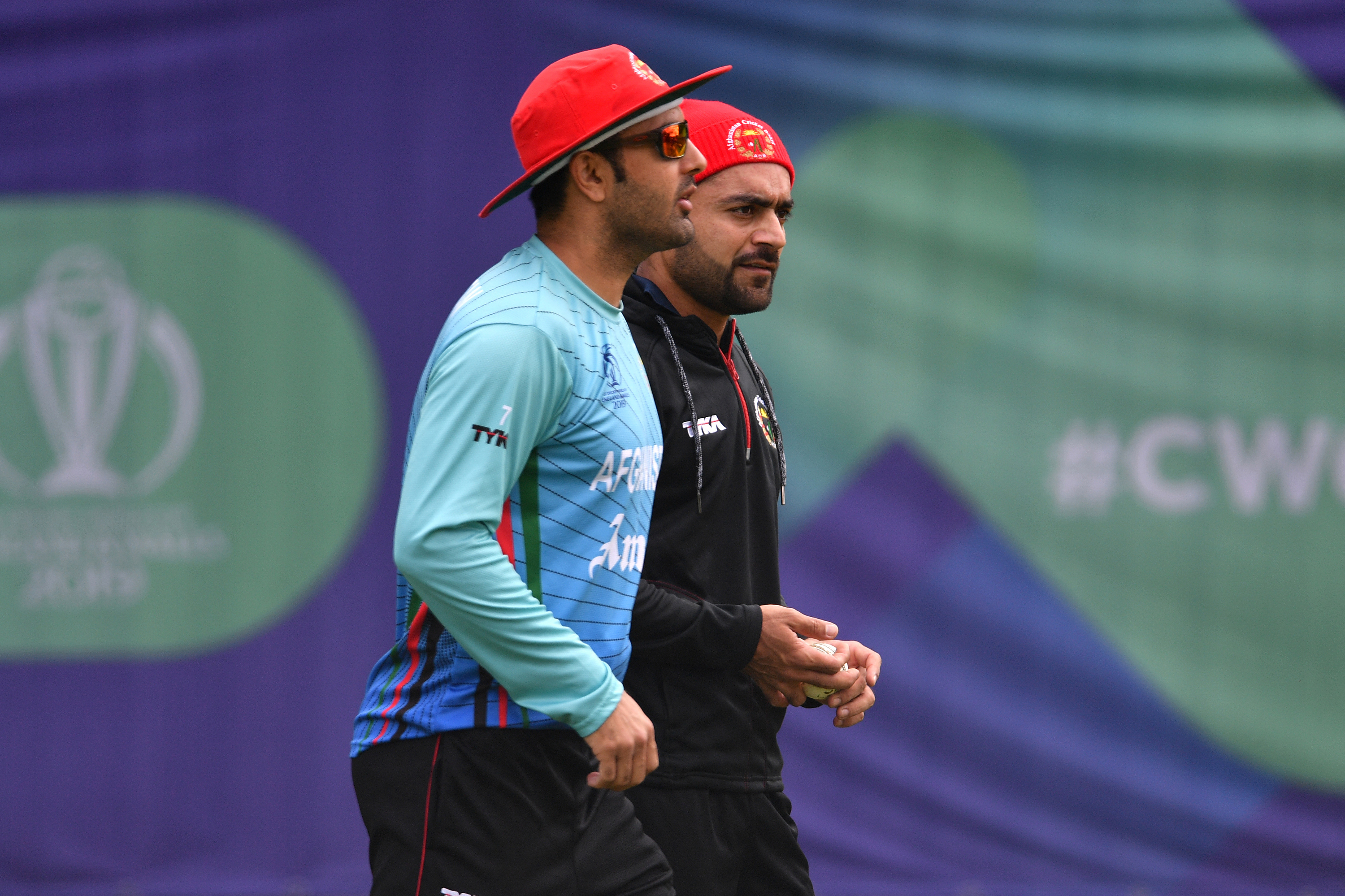 Afghanistan's Mohammad Nabi (L) and Afghanistan's Rashid Khan (R) prepare to bowl in the nets during a training session at the Rose Bowl in Southampton, southern England on June 21, 2019, ahead of their 2019 Cricket World Cup group stage match against India. (Photo by Saeed KHAN / AFP) / RESTRICTED TO EDITORIAL USE