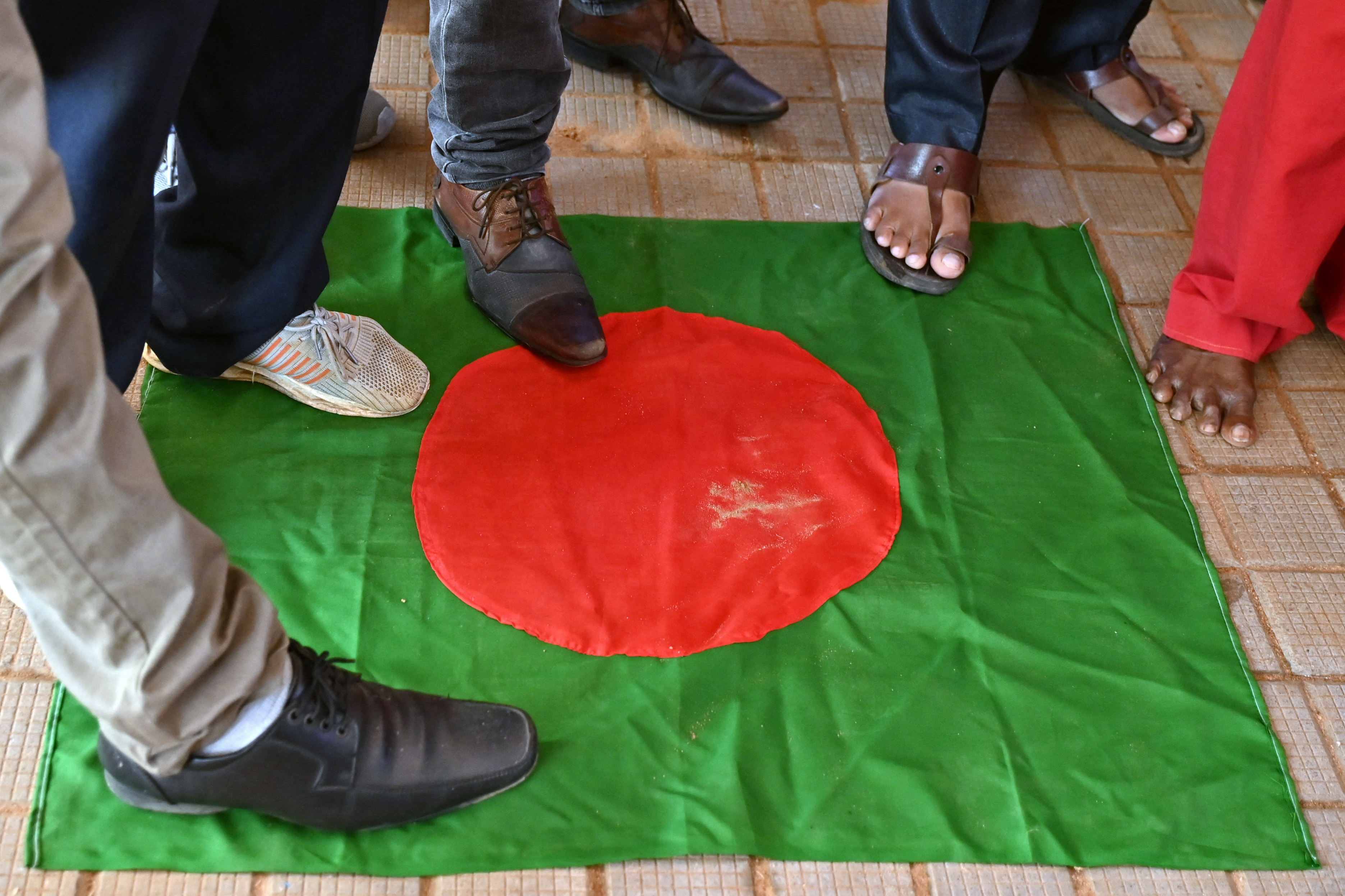 Members of the Hindu Hitarakshana Vedike step on Bangladesh's national flag during a protest at Freedom Park in Bengaluru on December 4, 2024, against the violence on Hindu minority community in Bangladesh. - Bangladesh on December 3, summoned New Delhi's ambassador after an attack on one of its consulates in India, the latest flare-up in strained ties between the neighbours. (Photo by Idrees MOHAMMED / AFP)