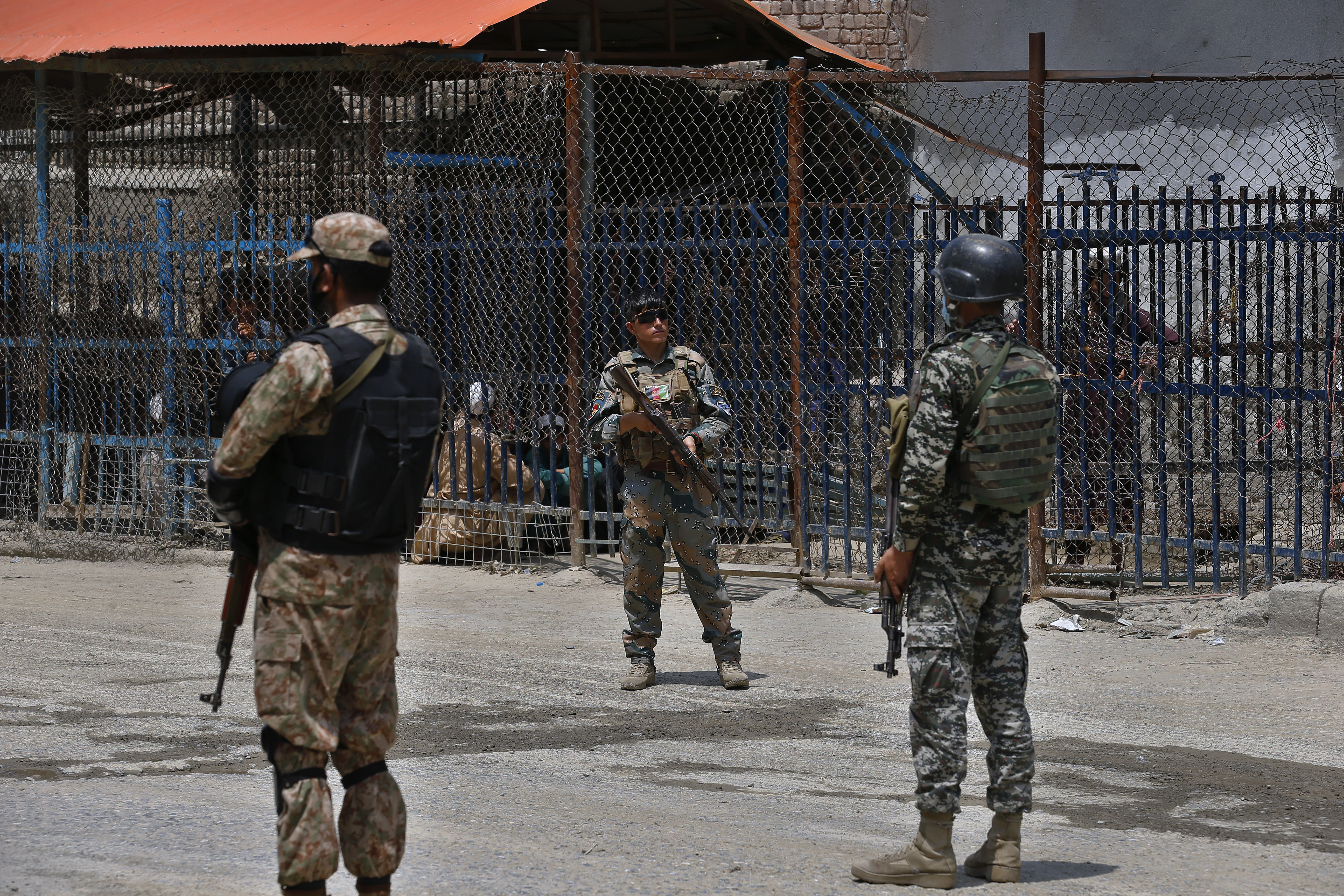 Pakistan and Afghan soldiers stand guard at Torkham border crossing.