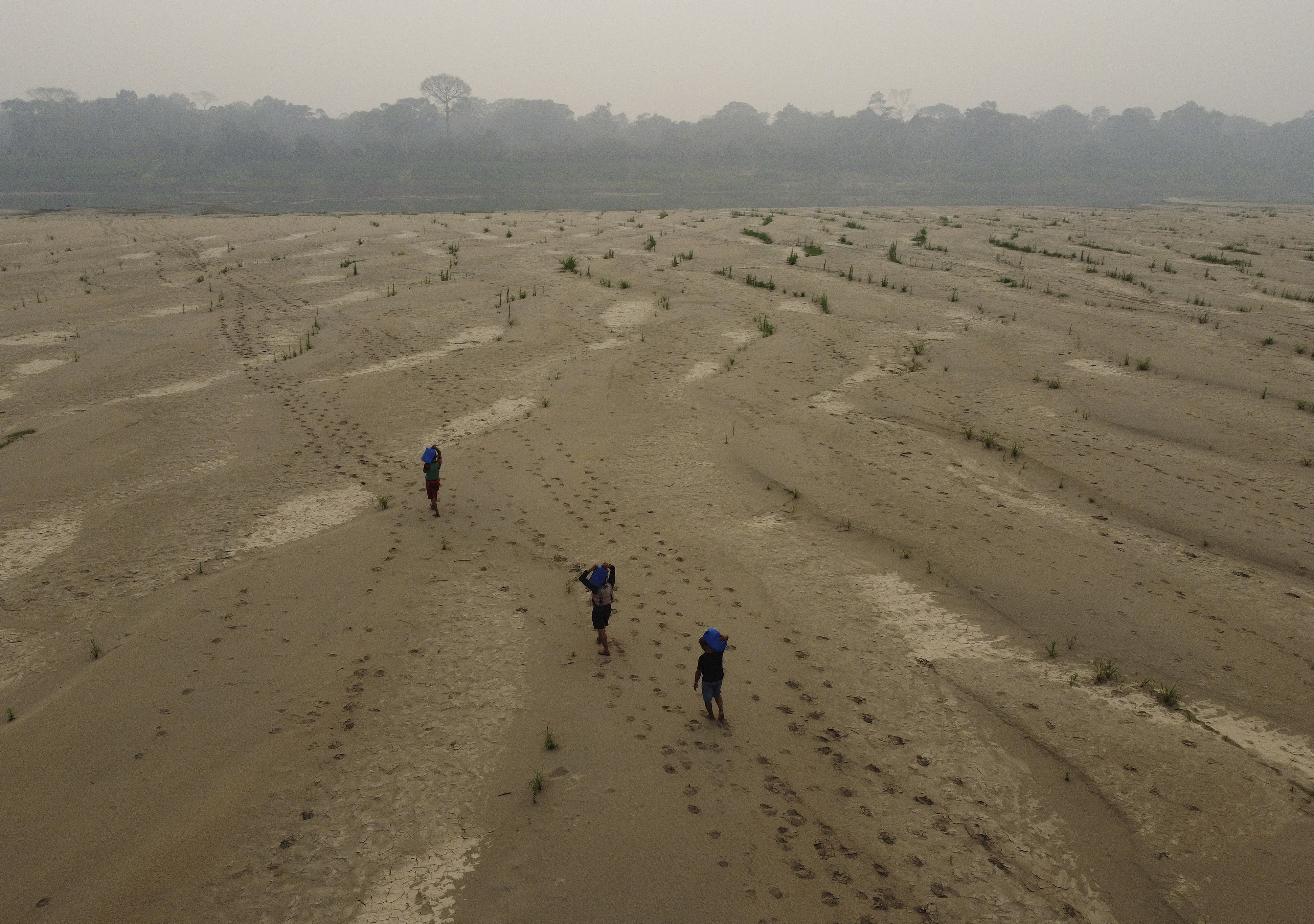 Residents transport drinking water from Humaita to the Paraizinho community, along the dry Madeira River, a tributary of the Amazon River, during the dry season, Amazonas state, Brazil, Sunday, Sept. 8, 2024