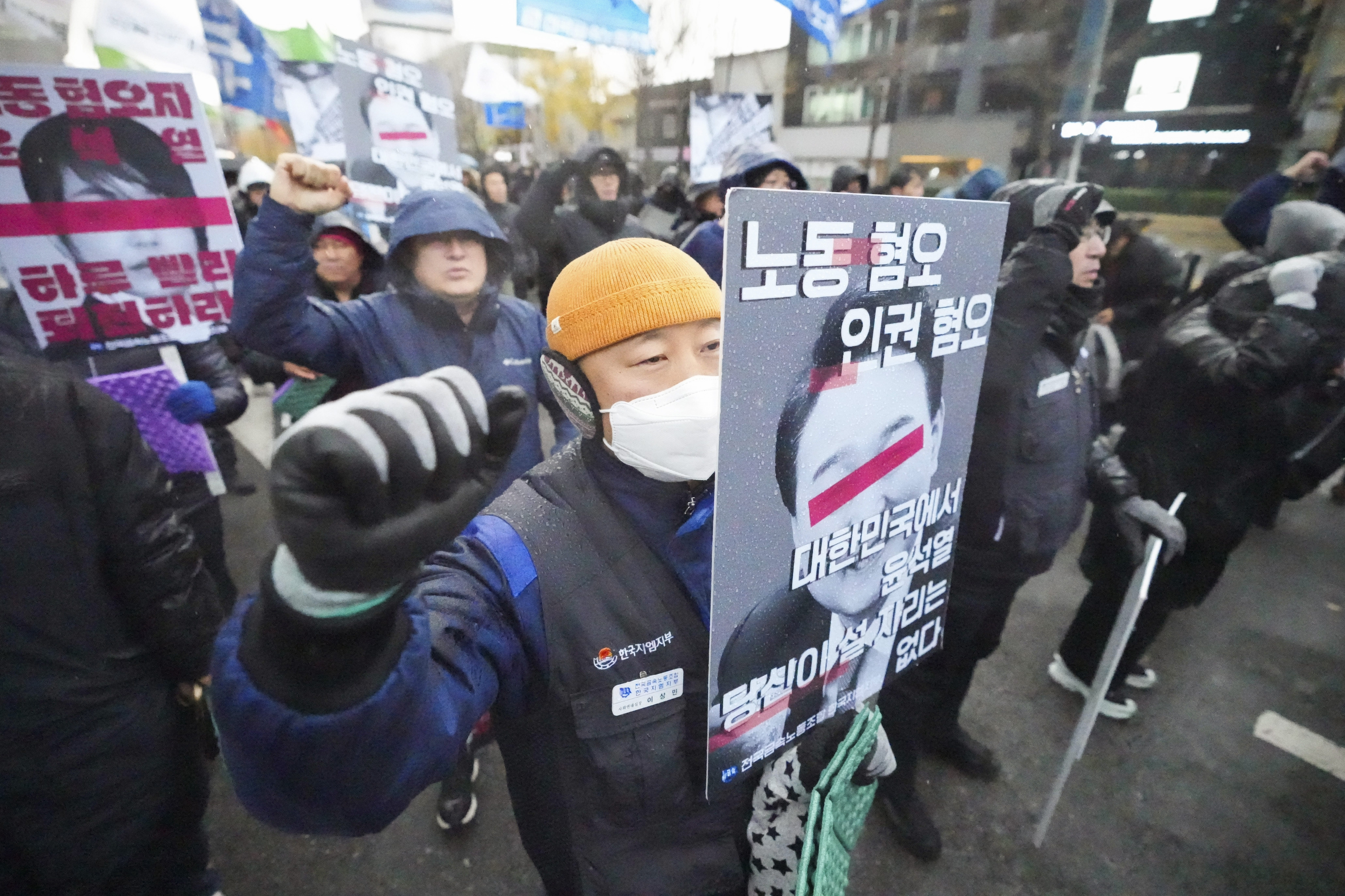 Protesters march after a rally against South Korean President Yoon Suk Yeol in Seoul, South Korea, Thursday, Dec. 5, 2024. The letters read "Disgust Human right, Disgust Labor." (AP Photo/Lee Jin-man)
