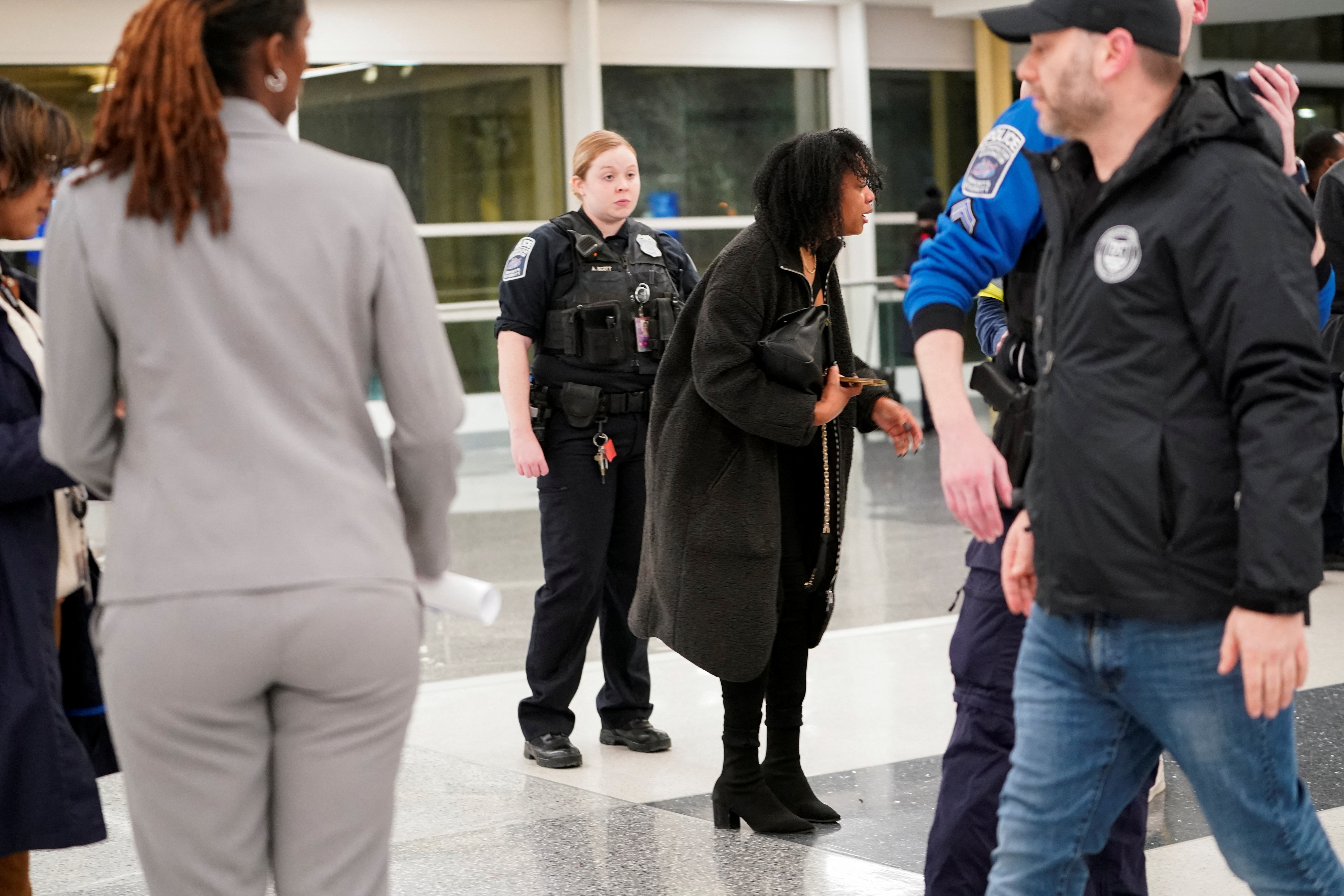 A woman reacts at Ronald Reagan National Airport after a crash between an aircraft and a helicopter