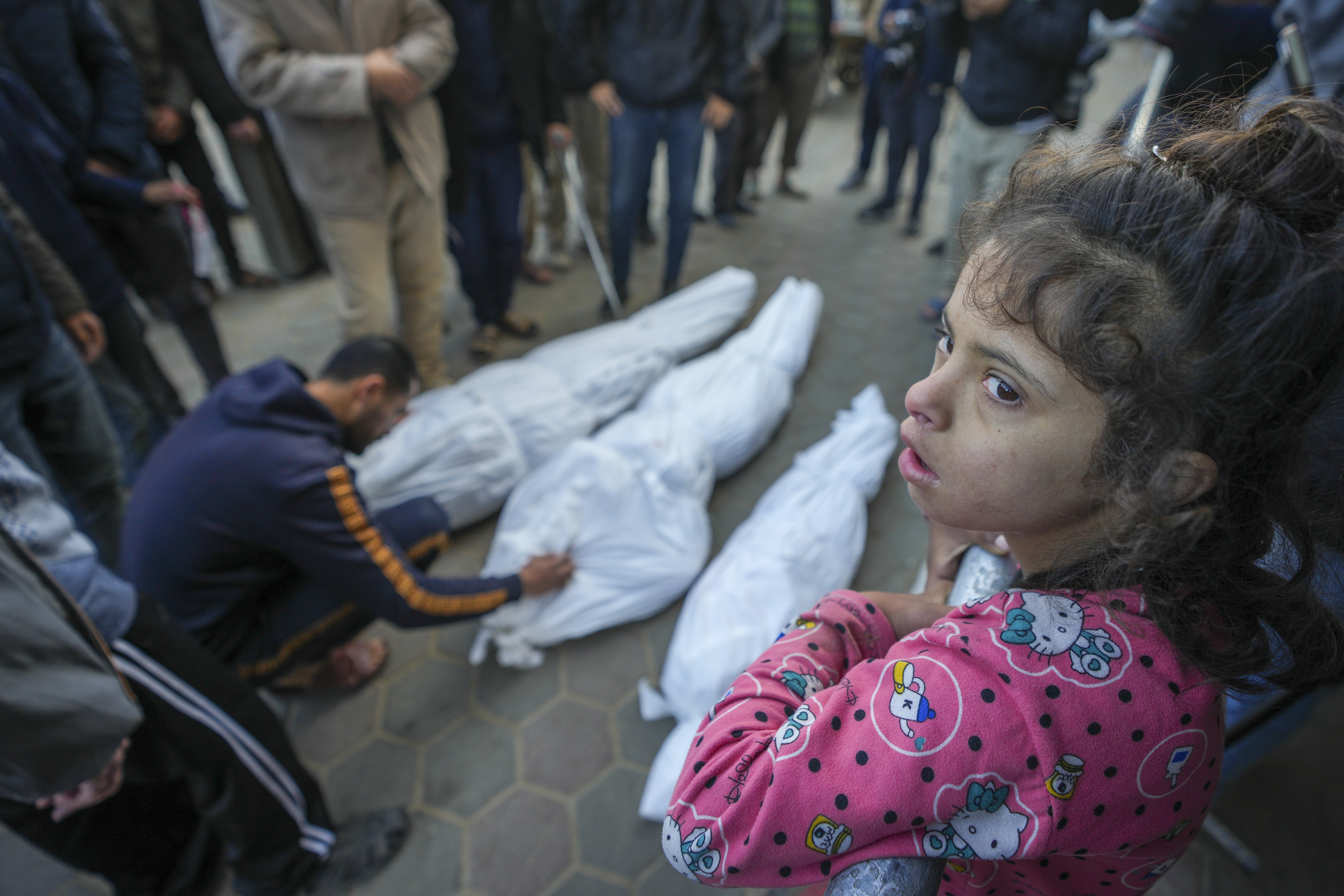 A girl watches as Mohammad Eid mourns his cousin Dima, along with her uncle and grandfather, who were killed in an Israeli airstrike, during their funeral in Deir el-Balah, January 12, 2025. [Abdel Kareem Hana/AP]