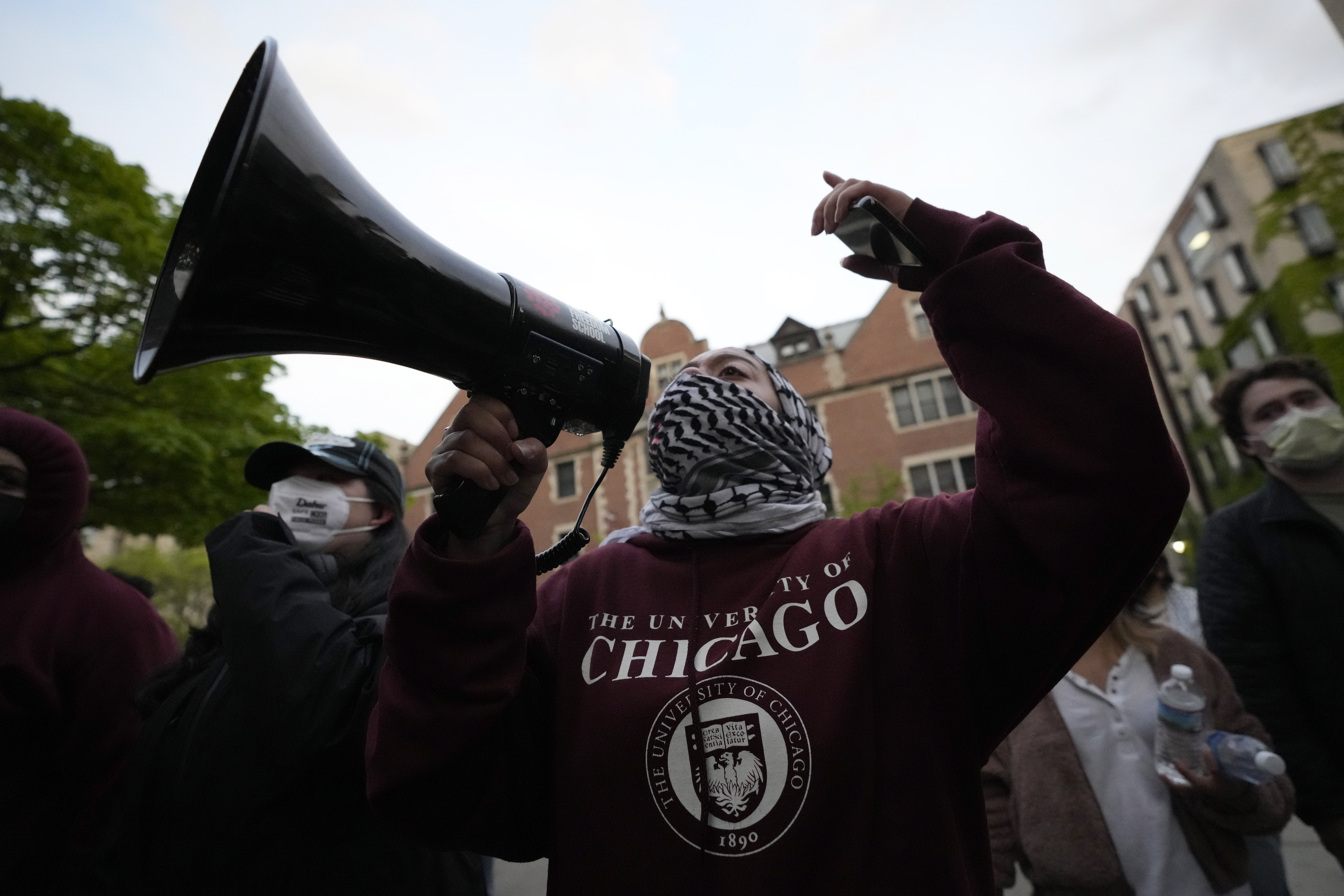A pro-Palestinian protester leads chants at the university's police as they are kept from the university's quad while the student encampment is dismantled at the University of Chicago