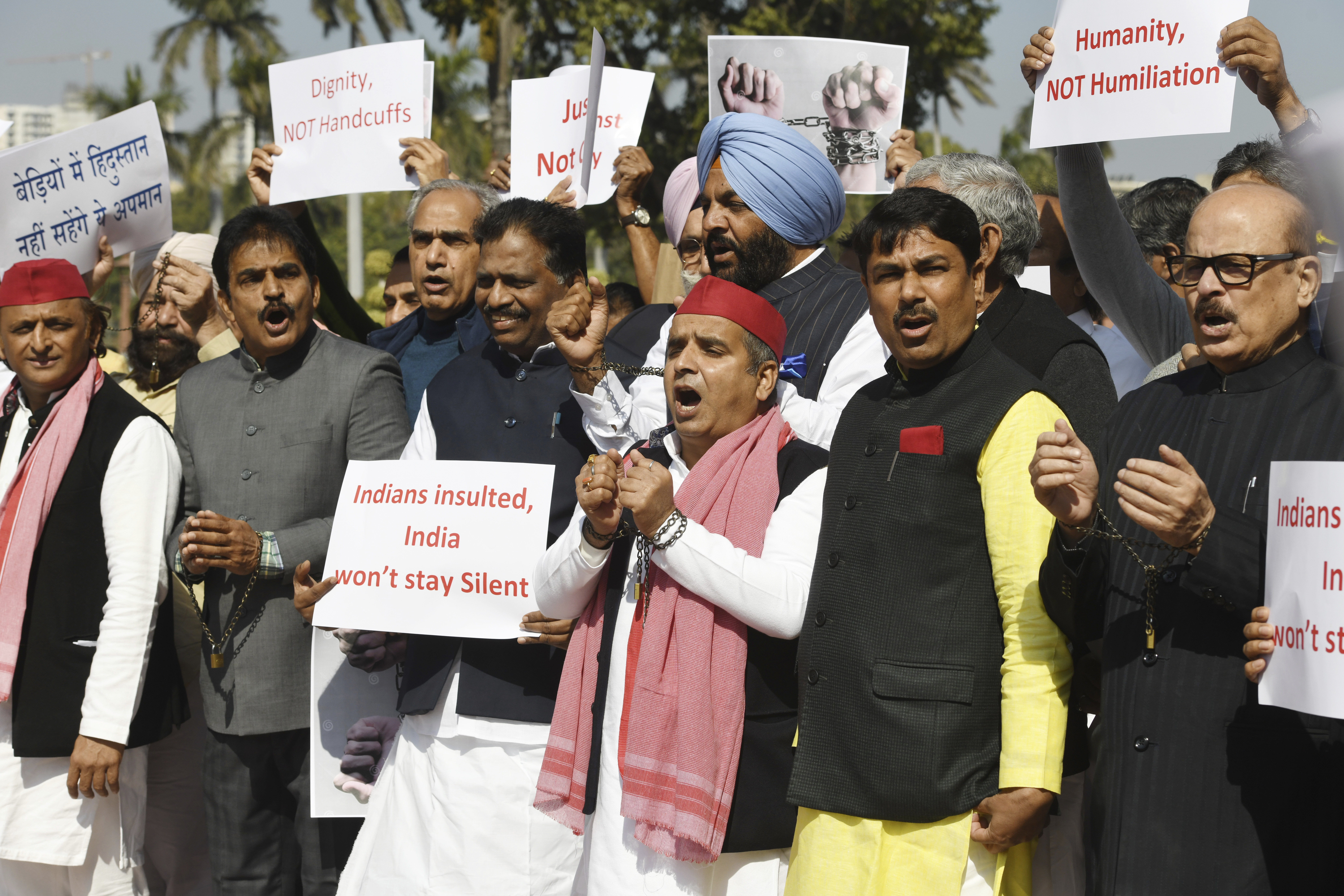 India's opposition lawmakers, some of them wearing shackles, stage a protest outside the Parliament in New Delhi, to condemn the reported mistreatment of Indian immigrants during their deportation from the United States, Thursday, Feb.6, 2025. The banners in Hindi language read "Indians in shackles, will not tolerate the insult." (AP Photo)
