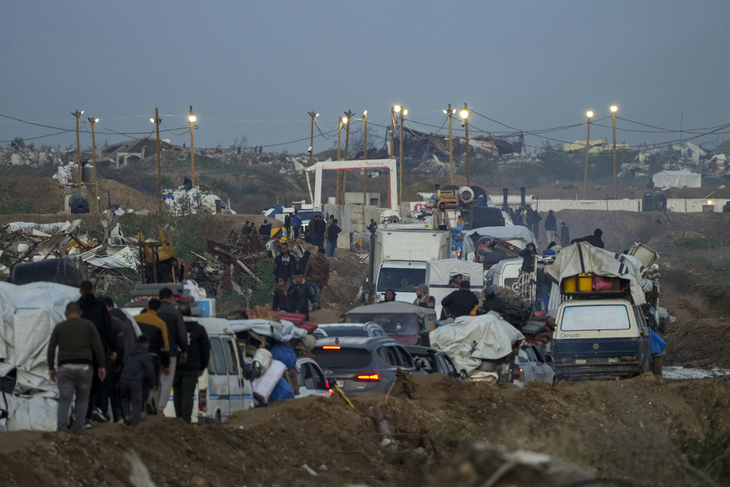 improvised lights surround cars driving through piles of dirt near a checkpoint