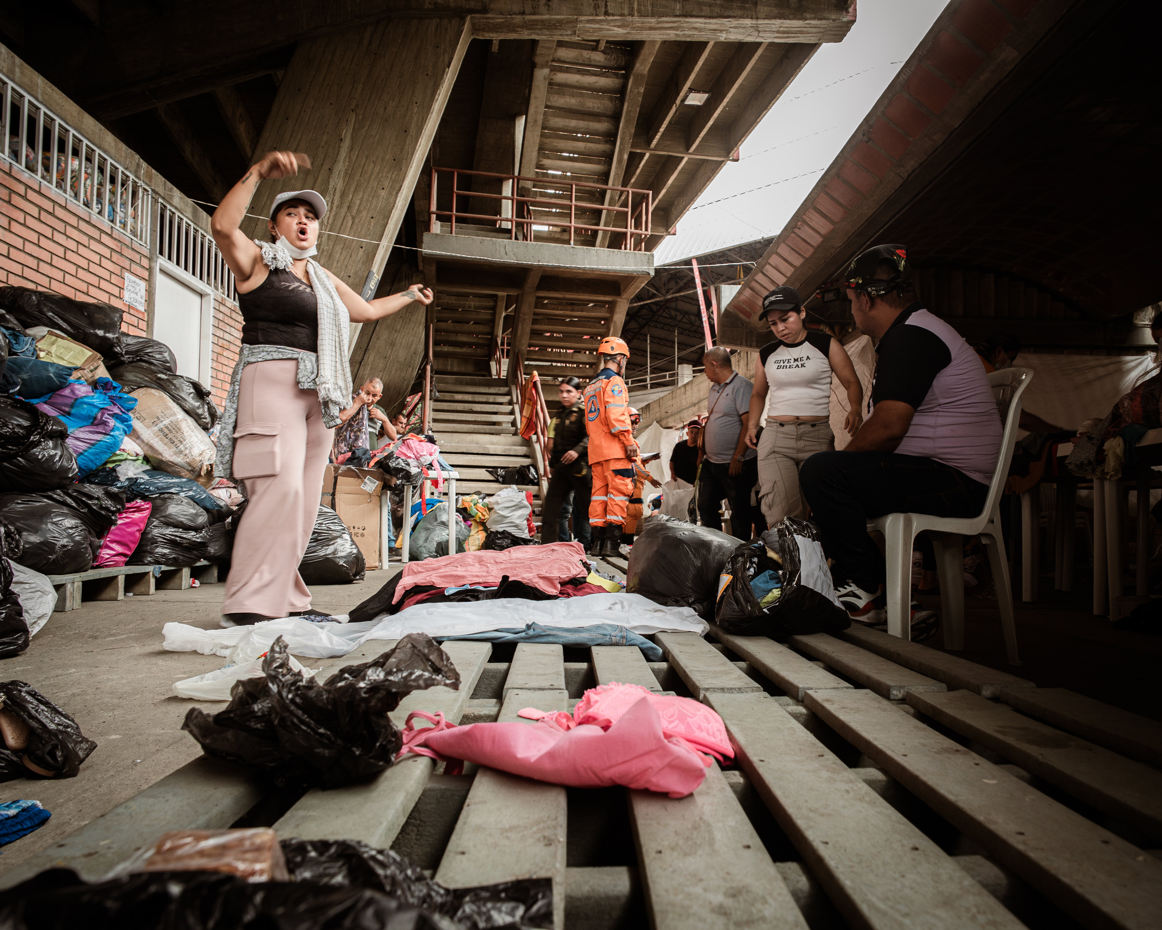 Volunteers in the General Santander Stadium gesture as they organise clothing donations