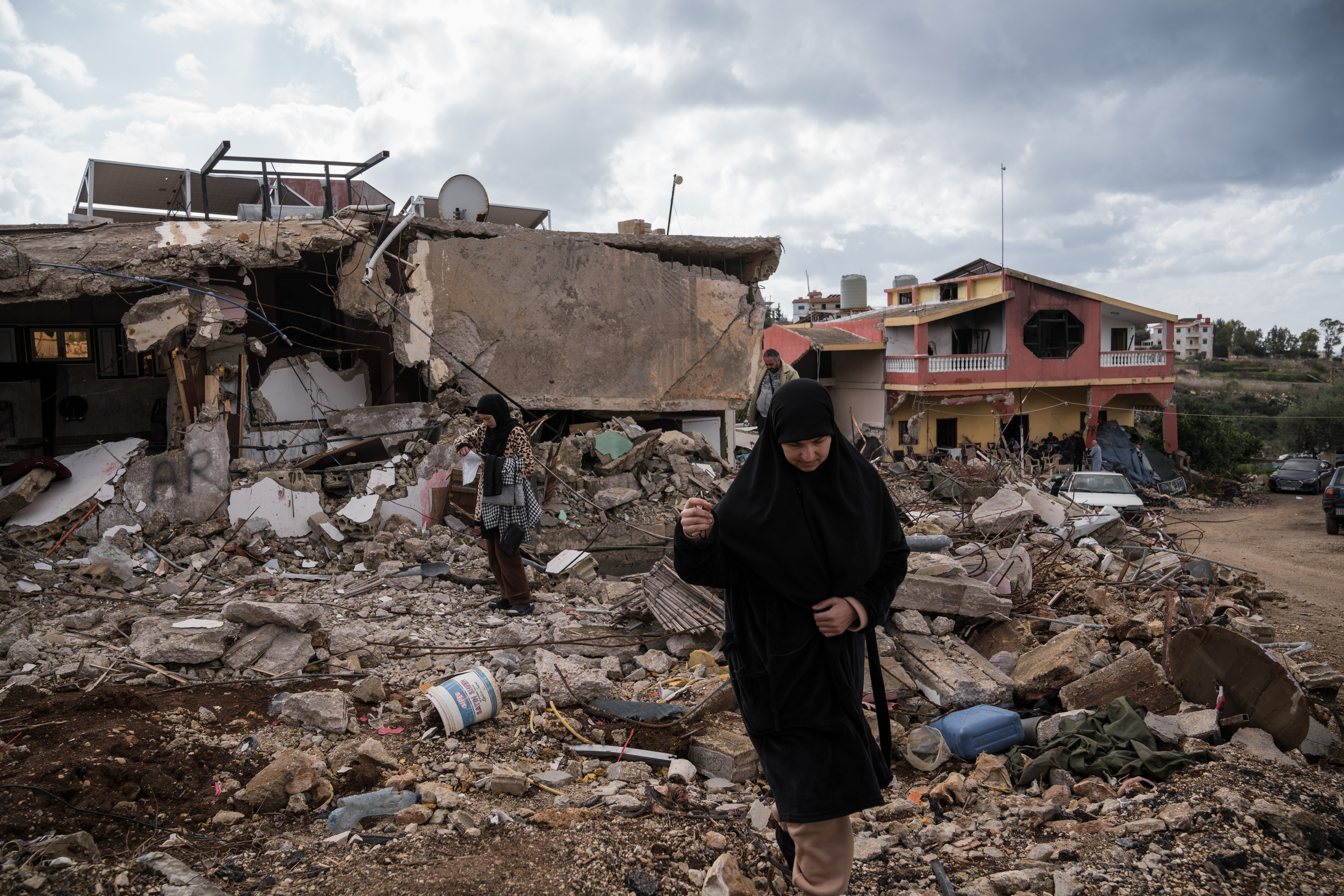 Ali Shaabi's relatives stand outside their homes destroyed during the ceasefire in Naqoura, south Lebanon