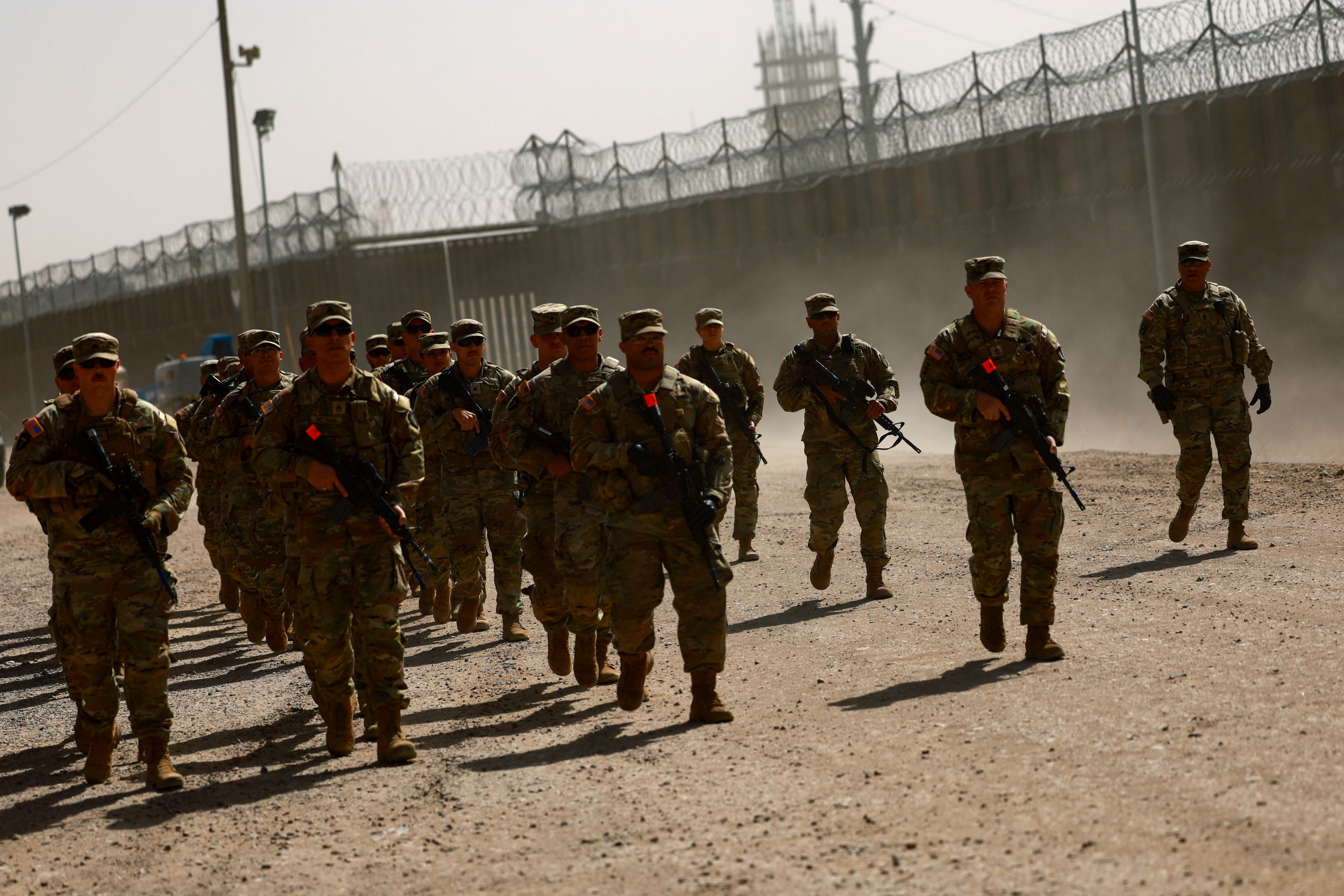 National Guard soldiers walk on the day U.S. authorities hold a ceremony to deputise the Texas National Guard to enforce Title 8 immigration laws, near the U.S.-Mexico border in El Paso, Texas, U.S. February 27, 2025.REUTERS/Jose Luis Gonzalez