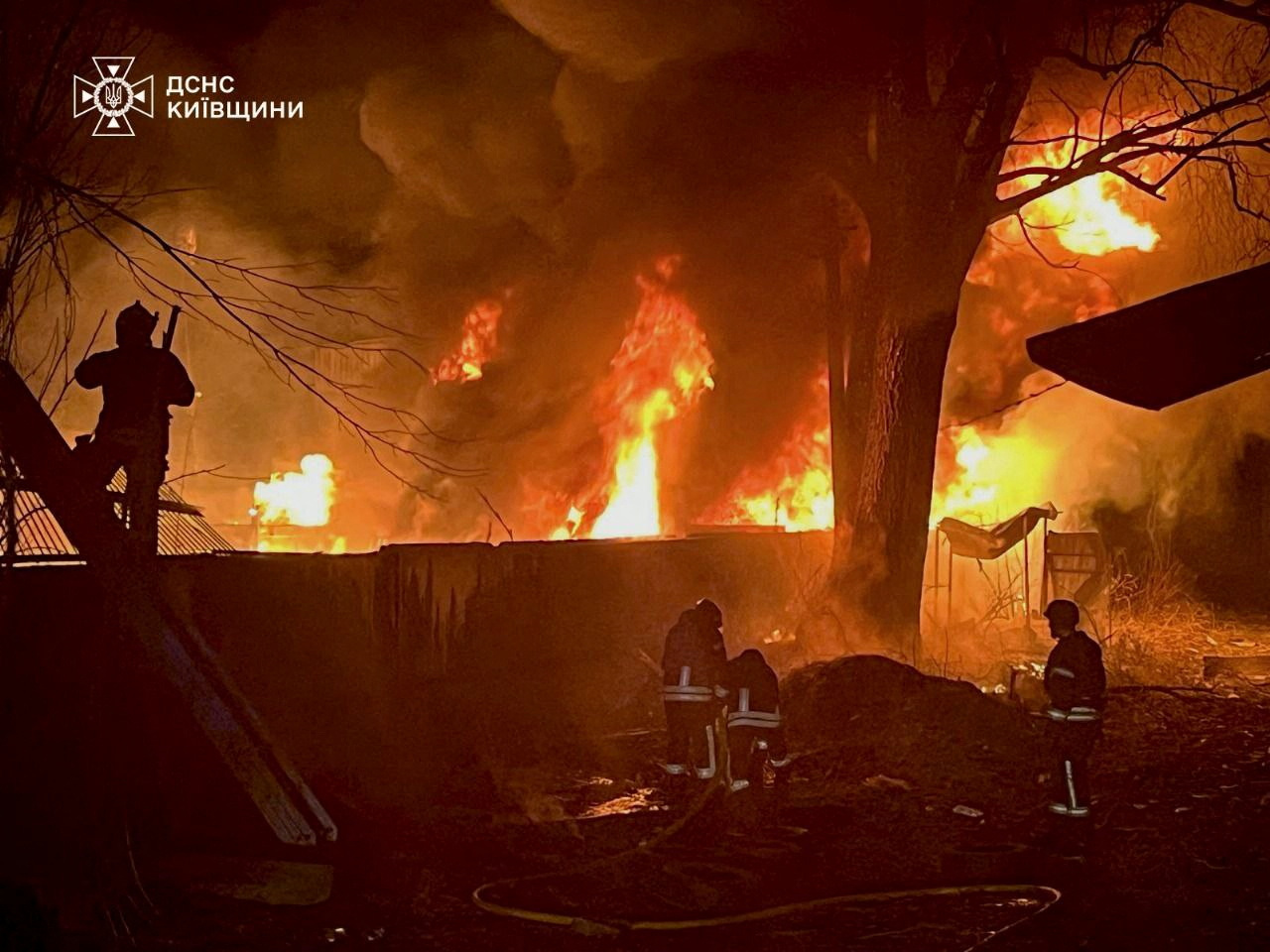 Firefighters work to extinguish a fire at a site of a Russian air attack in Kyiv