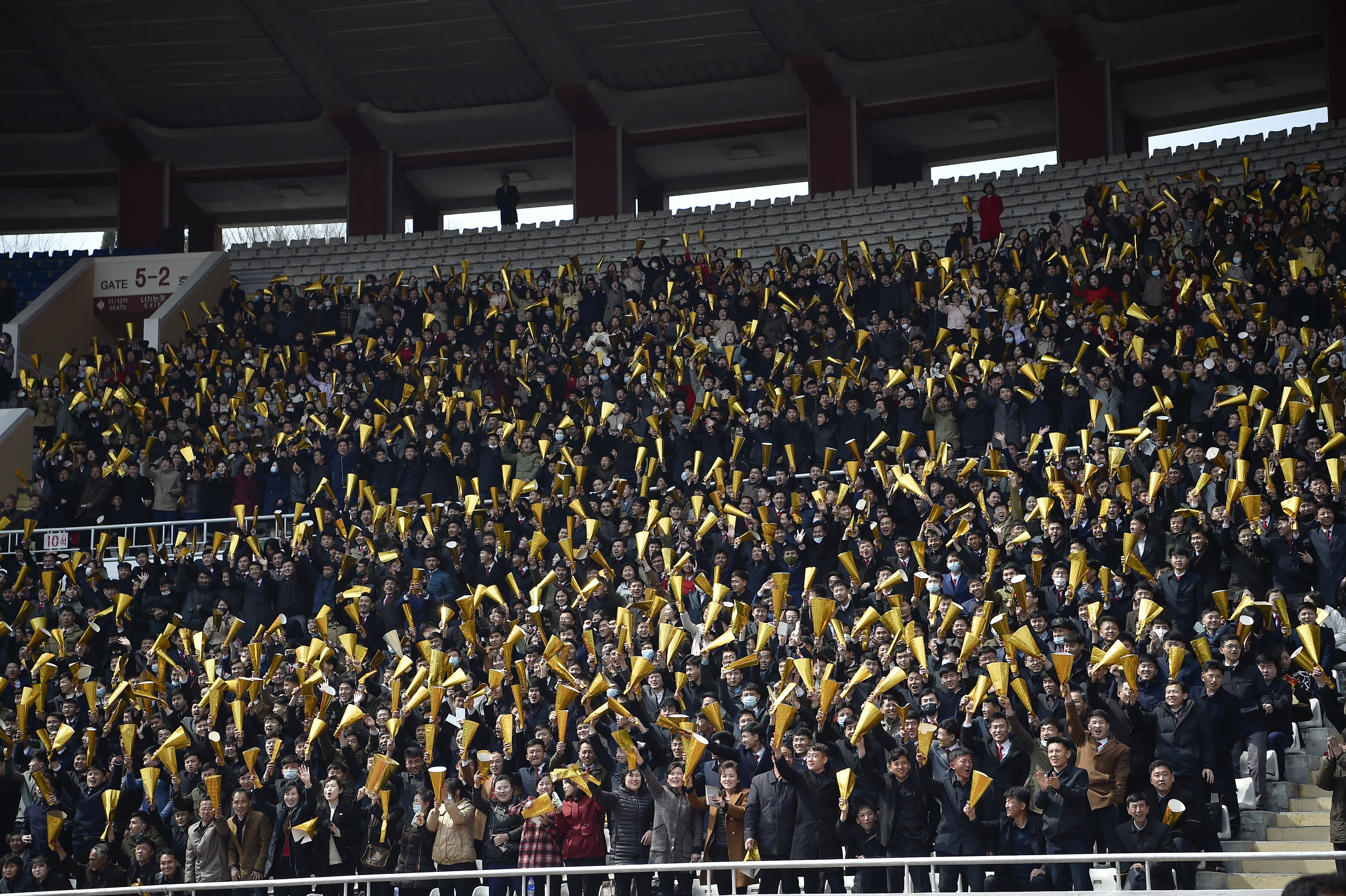 Spectators hold up hundreds of gold cones in the stands.