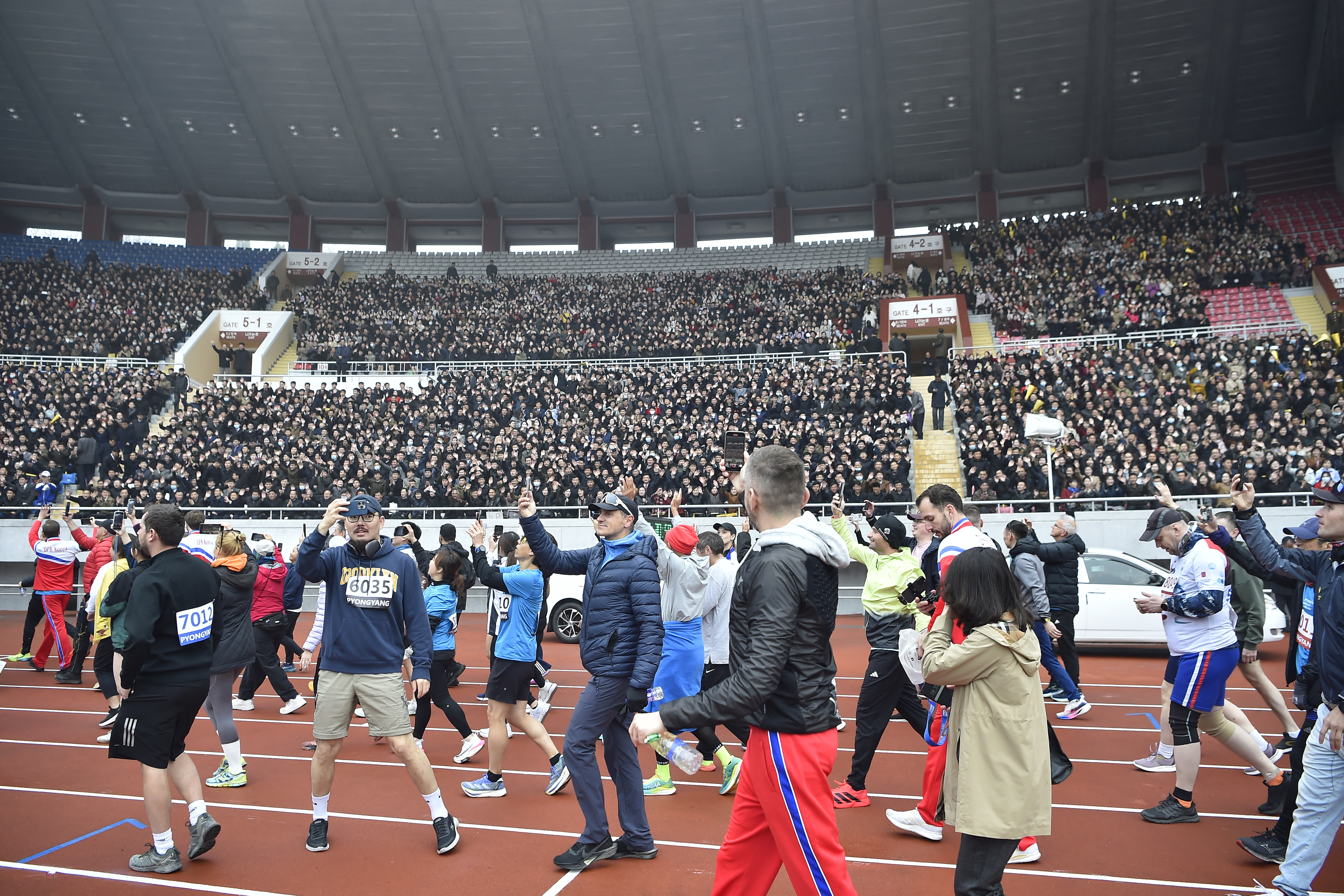 People on the track are taking pictures.