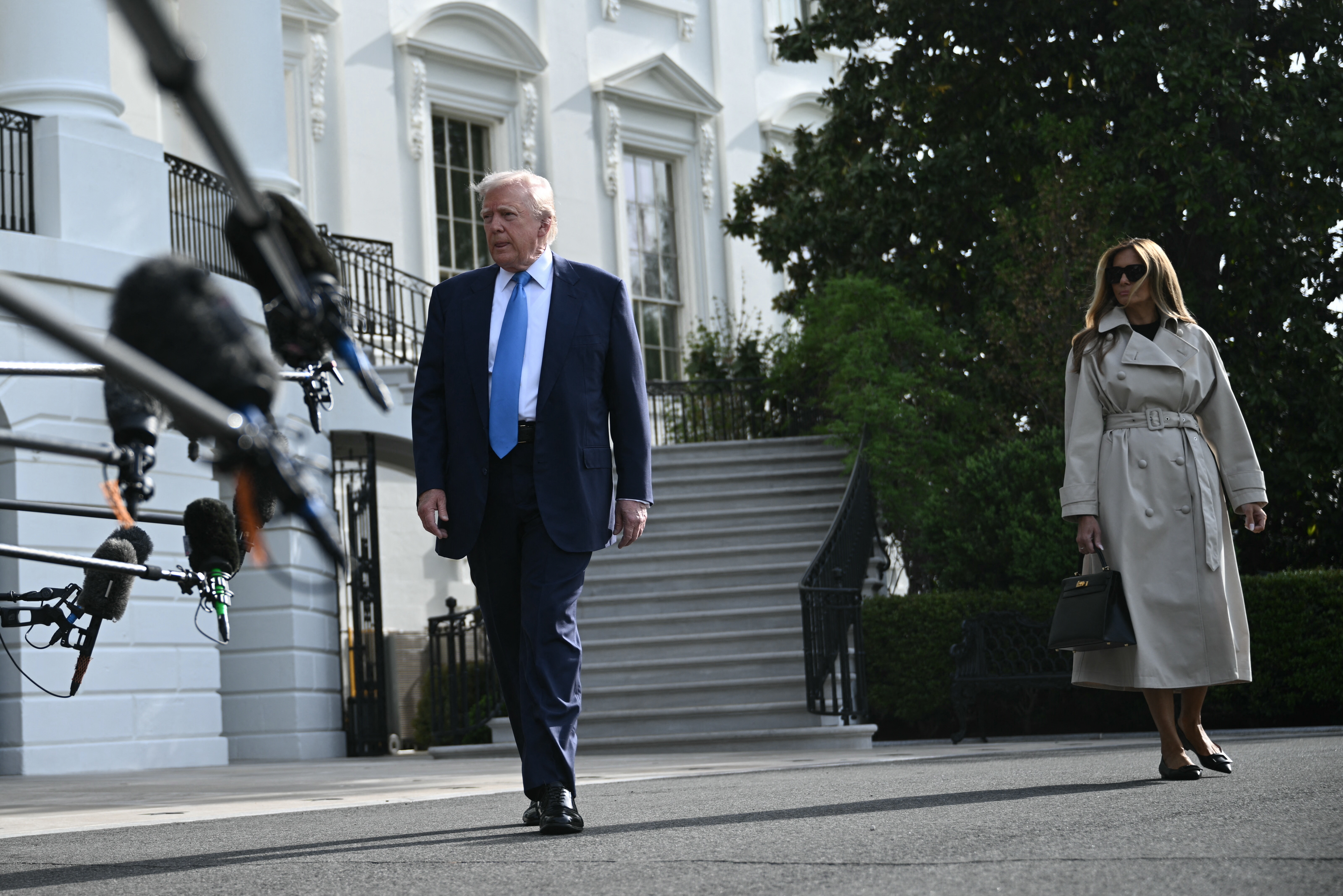 US President Donald Trump, with First Lady Melania Trump, speaks to the press before boarding Marine One on the South Lawn of the White House in Washington, DC, on April 25, 2025, en route to Joint Base Andrews. The president and first lady are traveling to Rome to attend the funeral of Pope Francis. (Photo by Brendan SMIALOWSKI / AFP)