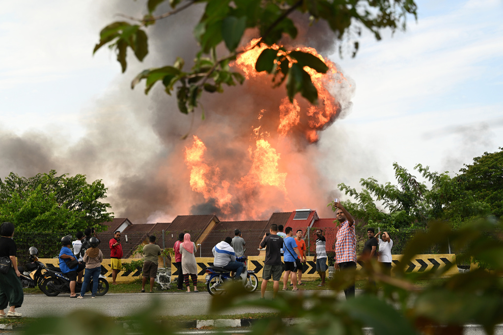 Residents watch a colossal fire erupt.