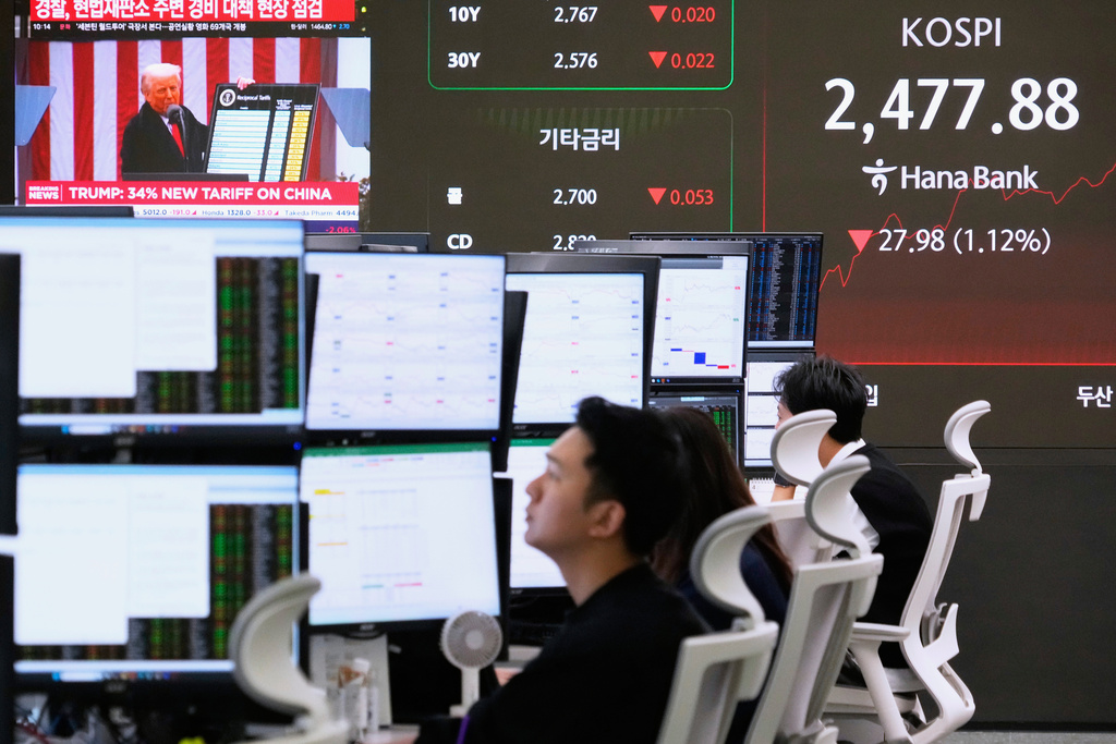 US President Donald Trump is seen on a screen as currency traders work.