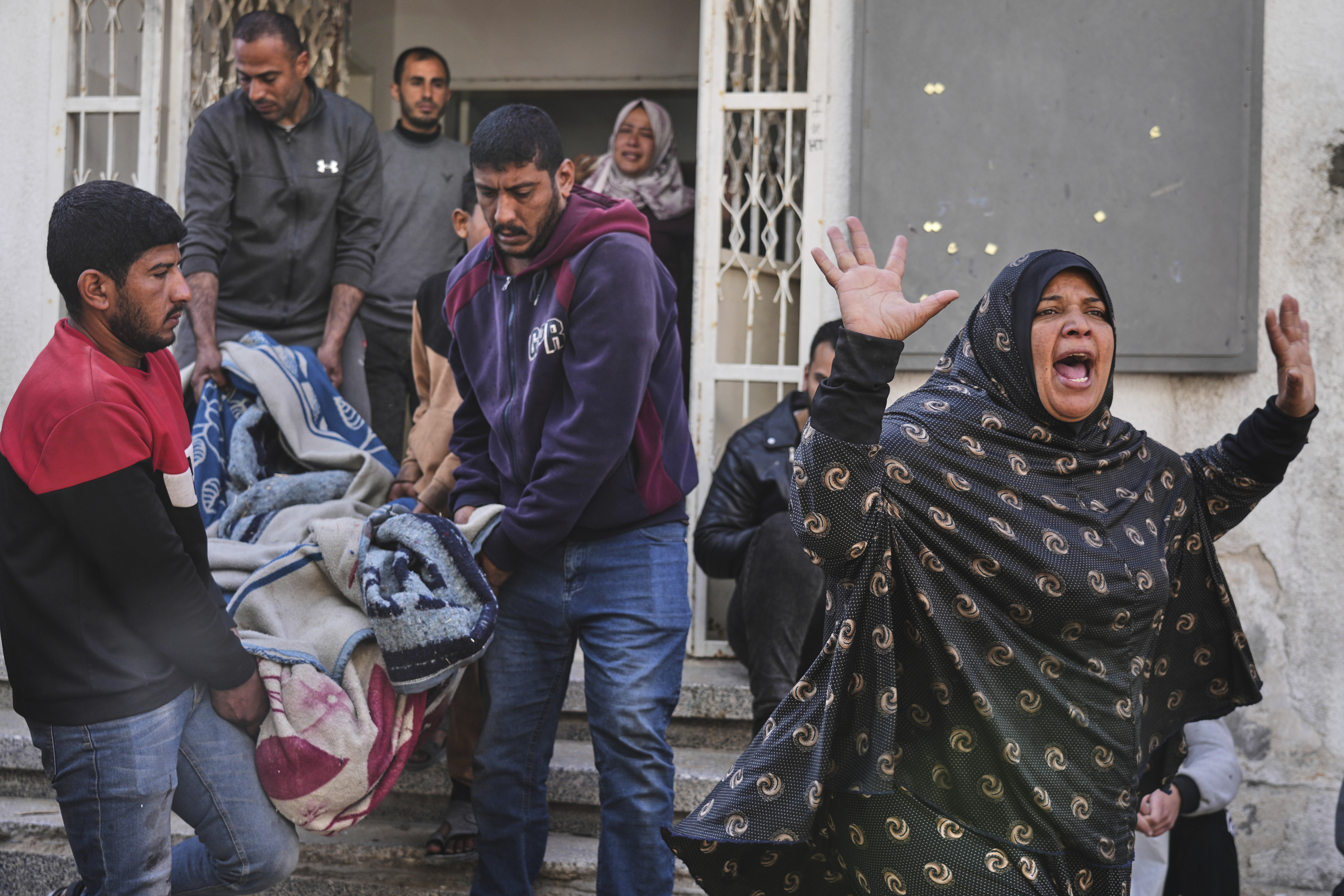 A Palestinian woman reacts as others carry the body of their relative, killed in an Israeli airstrike, in preparation for burial at Shifa Hospital in Gaza City
