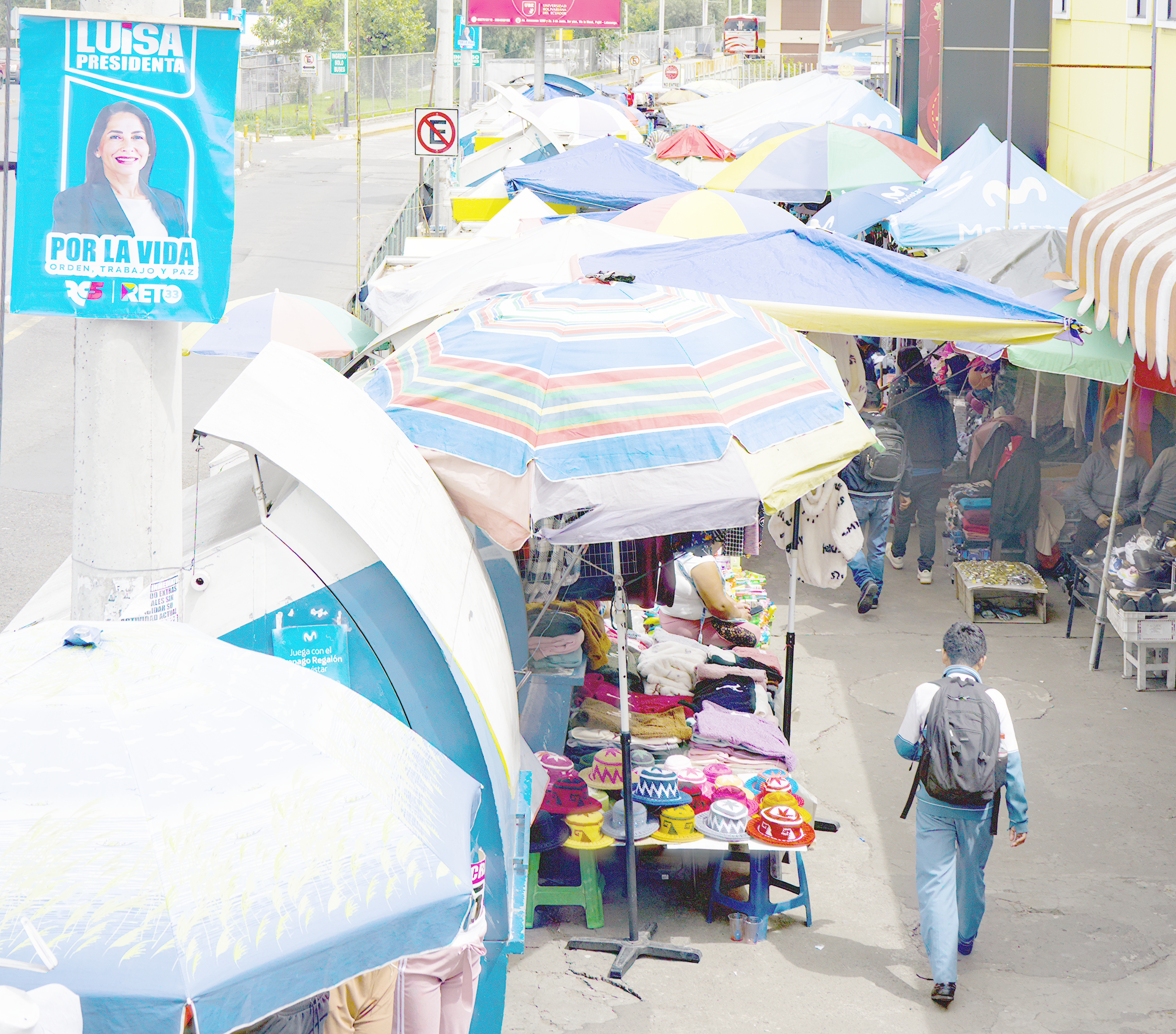 A poster advertising Luisa Gonzalez's presidential campaign is pinned to a pole near a market