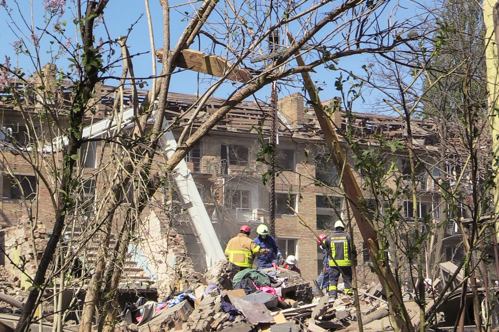 Rescue workers look for bodies in the debris of an apartment building destroyed by a Russian missile on early Thursday