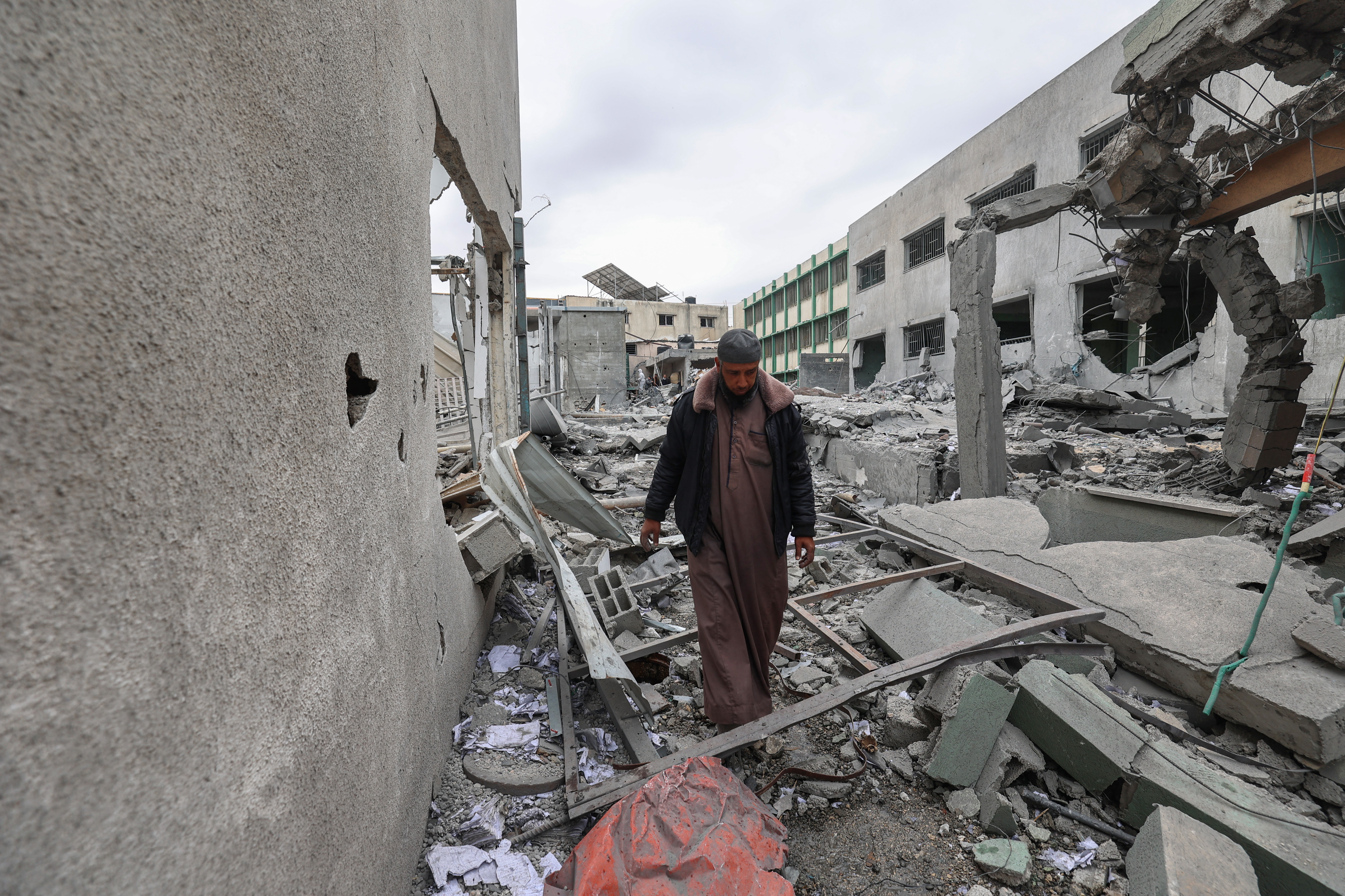 A Palestinian man inspects the destruction at the Deir el-Balah municipality headquarters due to Israeli strikes in the central Gaza Strip on April 13, 2025. (Photo by Eyad BABA / AFP)