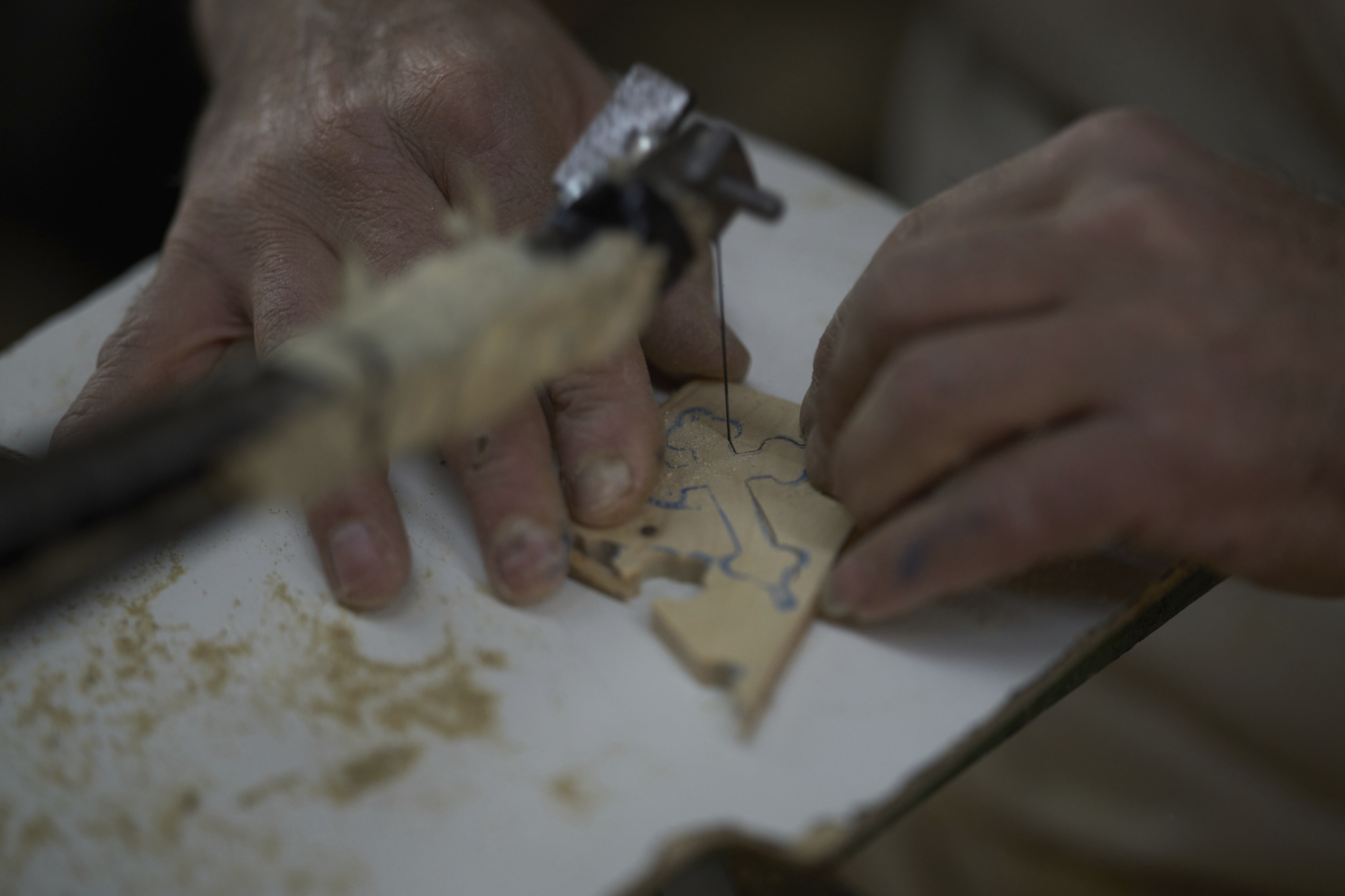 A Palestinian woodcarver shapes crosses made from olive wood in the occupied West Bank town of Bethlehem
