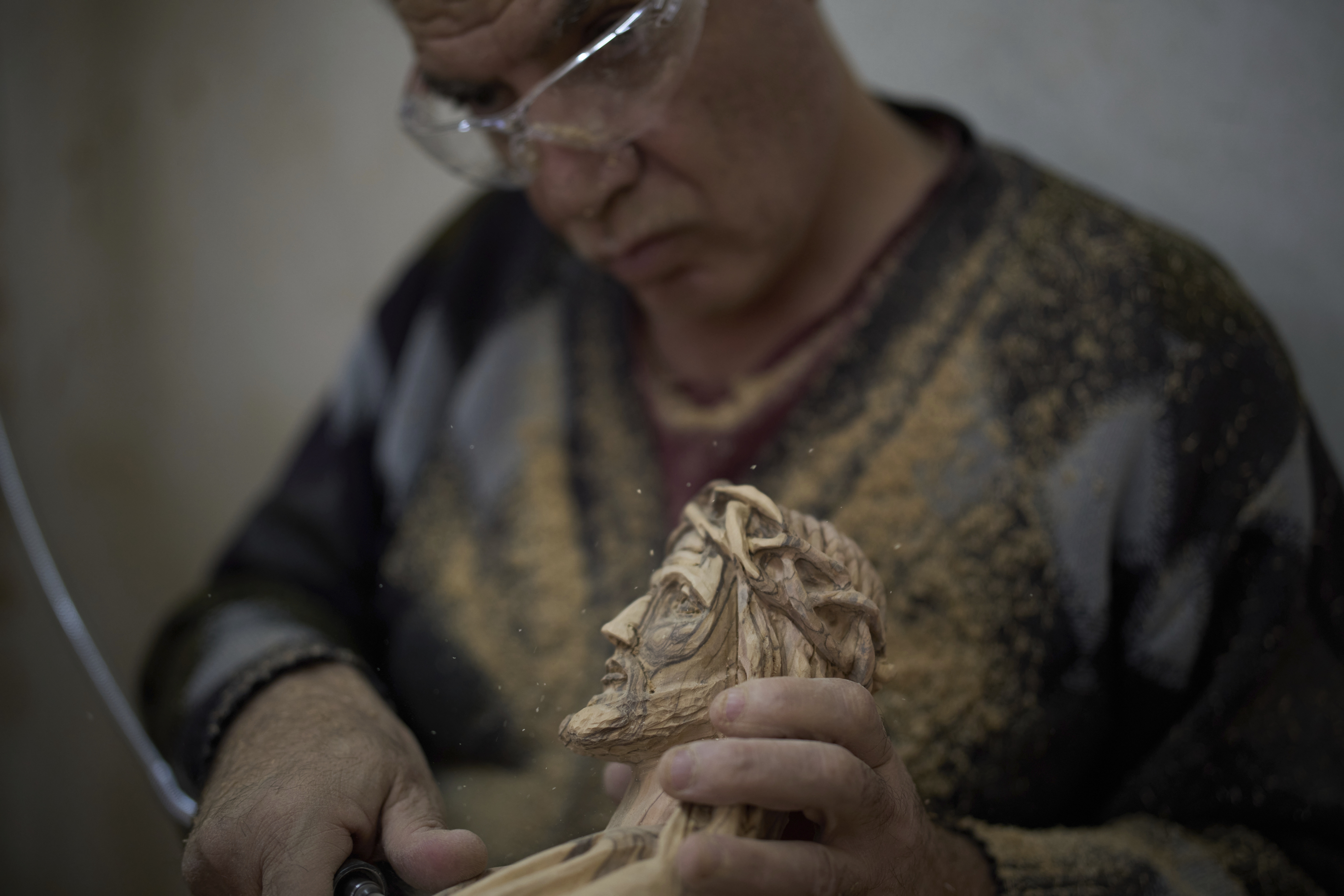 A Palestinian man carves an olive-wood sculpture of Jesus Christ at the Zacharia workshop before Holy Week celebrations in the West Bank city of Bethlehem on Tuesday, April 8, 2025. (AP Photo/Leo Correa)
