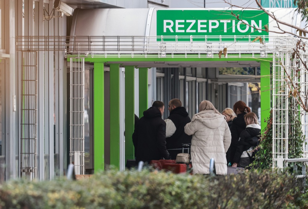 epa11714741 Migrants walk in front of the former Grand City Hotel Berlin at street Landsberger in Berlin, Germany, 11 November 2024. Refugees from the large accommodation center in Tegel moved into the Grand City Hotel. Several refugees are to be accommodated in the new center until the beginning of December. The refugees are asylum seekers from various countries as well as war refugees from Ukraine. EPA-EFE/HANNIBAL HANSCHKE
