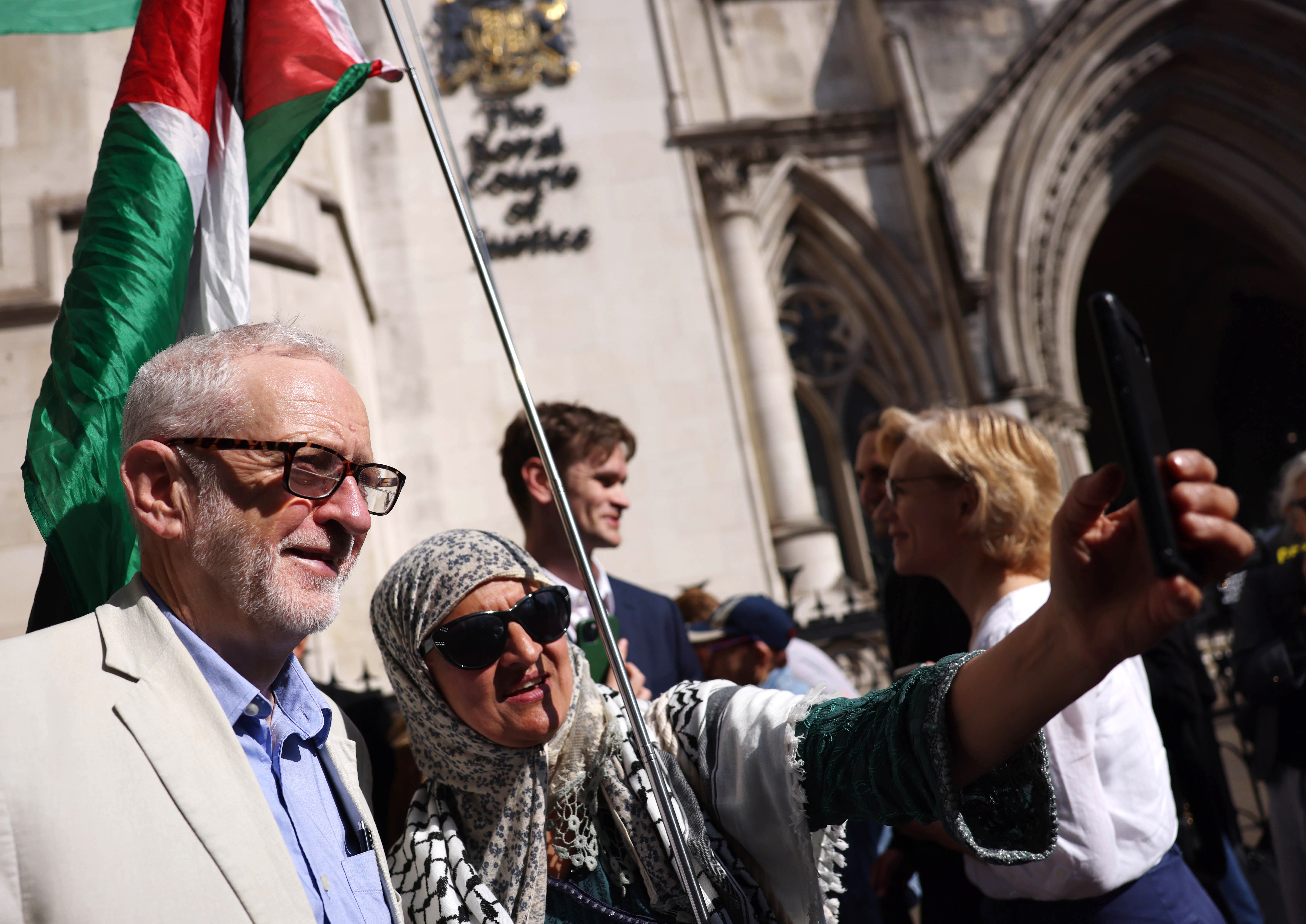 epa12095697 Former opposition Labour Party leader Jeremy Corbyn (L) poses for a selfie with a participant as he joins protesters demonstrating against selling arms to Israel at the Royal Courts of Justice in London, Britain, 13 May 2025. A four-day judicial review brought by Palestinian rights group Al-Haq and the Global Legal Action Network (GLAN) starts in the High Court on 13 May, with human rights' groups and lawyers arguing that UK's sale of arms to Israel is unlawful. EPA-EFE/NEIL HALL