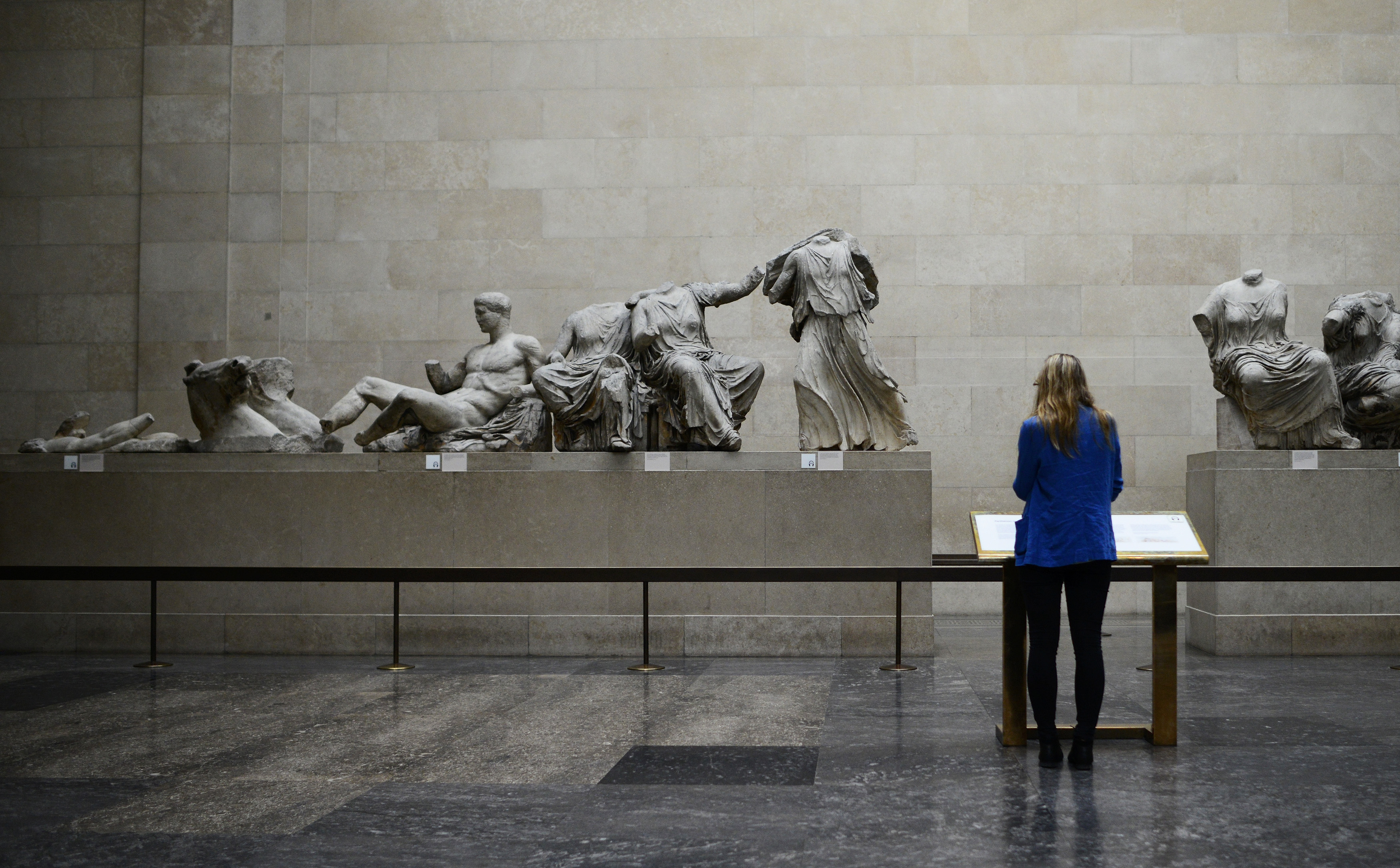 A woman looks at the Parthenon Marbles, a collection of stone objects, inscriptions and sculptures, also known as the Elgin Marbles, on show at the British Museum in London October 16, 2014. Hollywood actor George Clooney's new wife, human rights lawyer Amal Alamuddin Clooney, made an impassioned plea on for the return of the Parthenon Marbles to Athens, in what Greeks hope may inject new energy into their national campaign. REUTERS/Dylan Martinez (BRITAIN - Tags: ENTERTAINMENT POLITICS SOCIETY)