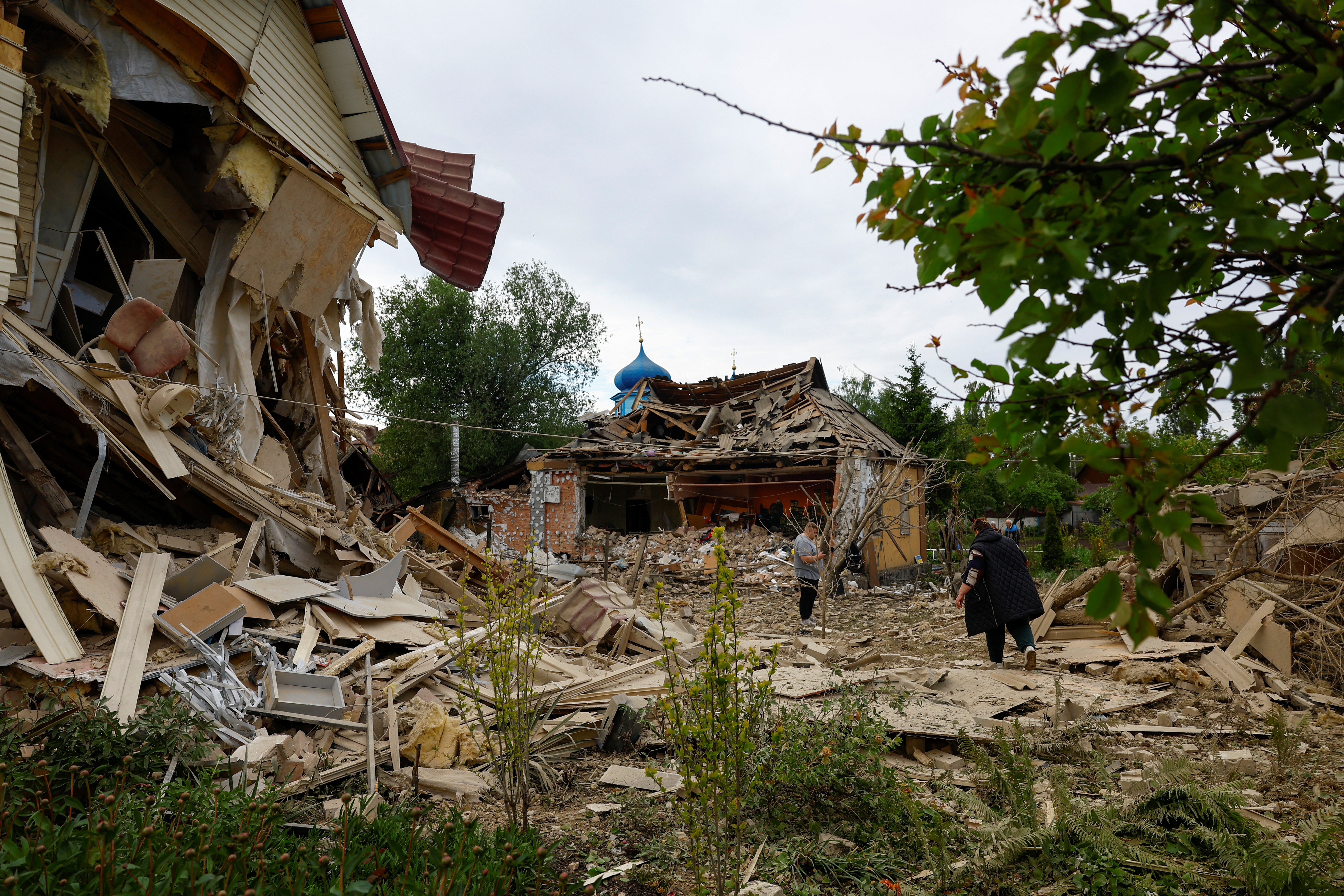 People next to the houses heavily damaged by a Russian drone attack outside Kyiv, Ukraine