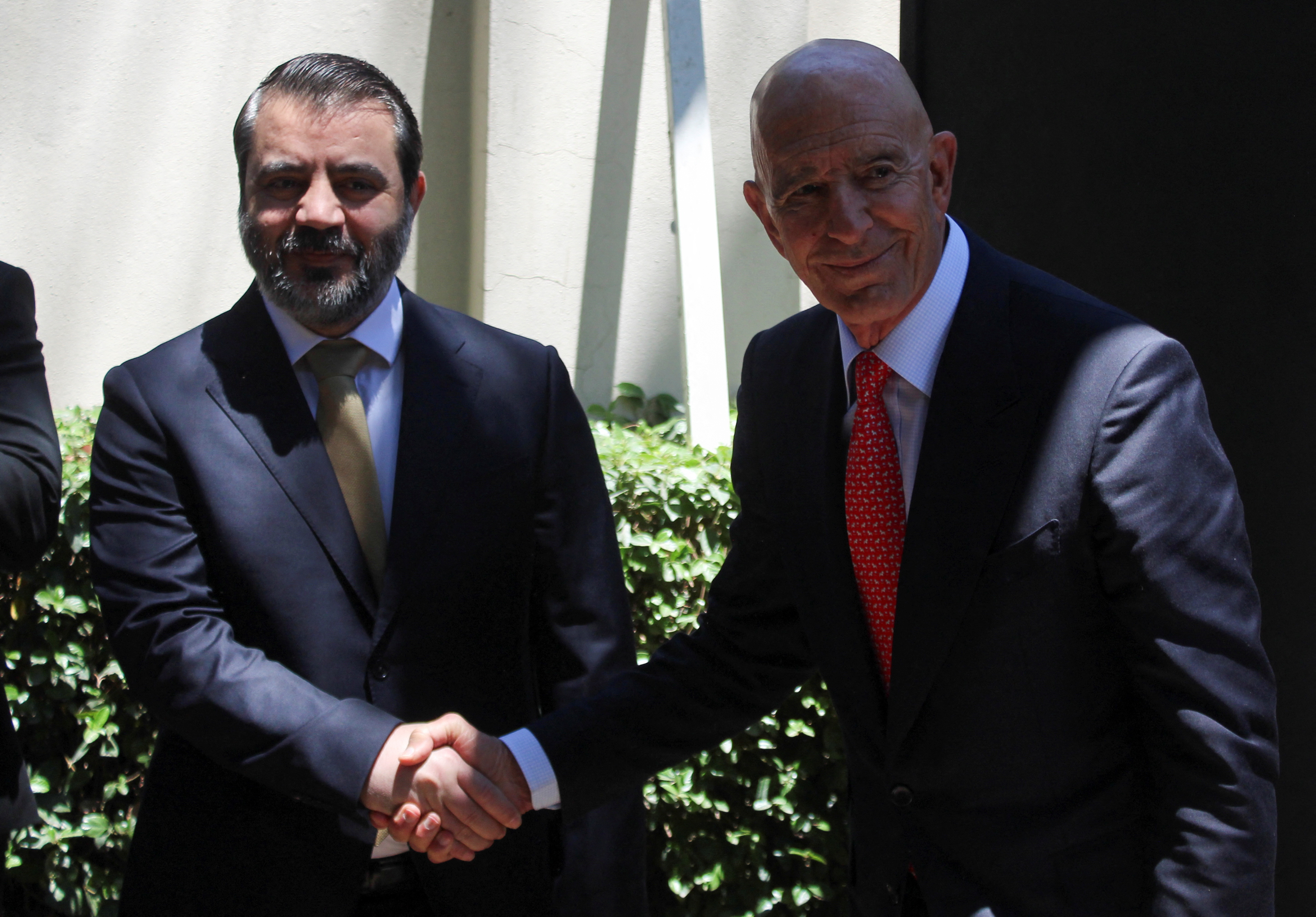 Syrian Foreign Minister Asaad Hassan al-Shibani shakes hands with U.S. envoy for Syria Thomas Barrack