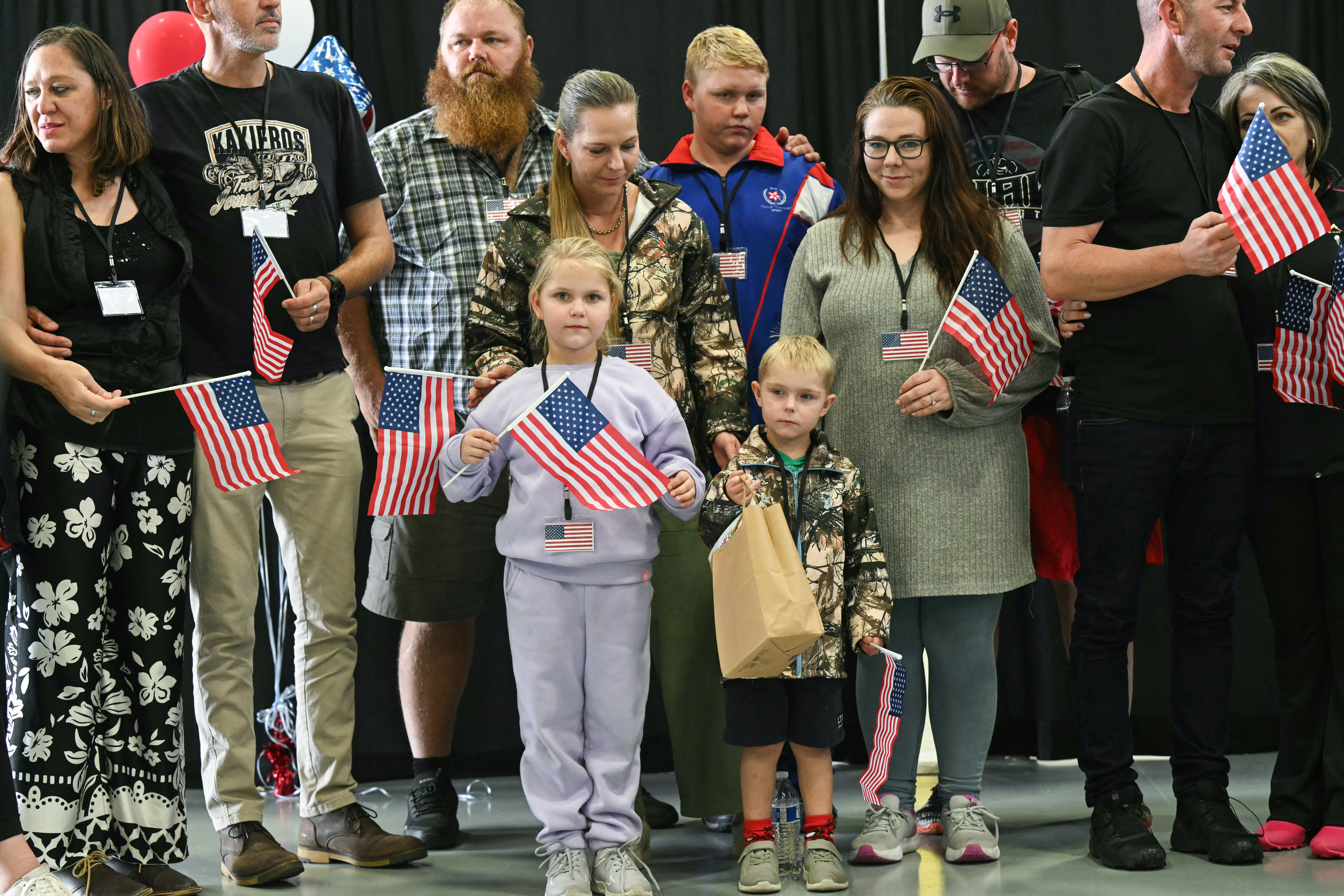 Group of people standing and holding small US flags.