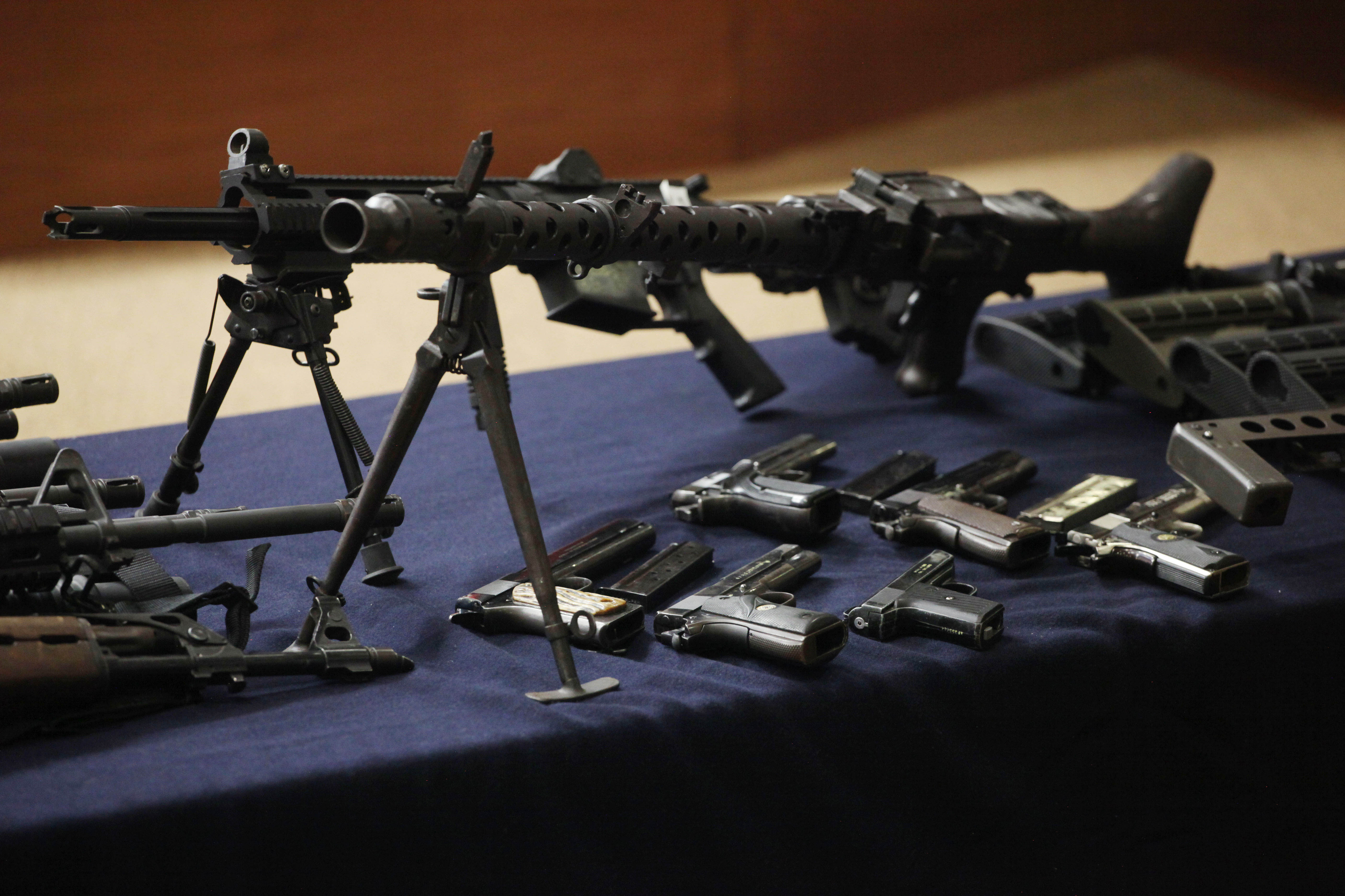 Seized weapons allegedly seized from suspect Erick Valencia Salazar, alias "El 85," not in the picture, sit on display during Salazar's presentation to the press in Mexico City, Monday March 12, 2012. Salazar, alleged leader of "Cartel de Jalisco Nueva Generacion," or "New Generation" drug gang, was arrested in Guadalajara by the army on Friday March 9, according to authorities. (AP Photo/Alexandre Meneghini)