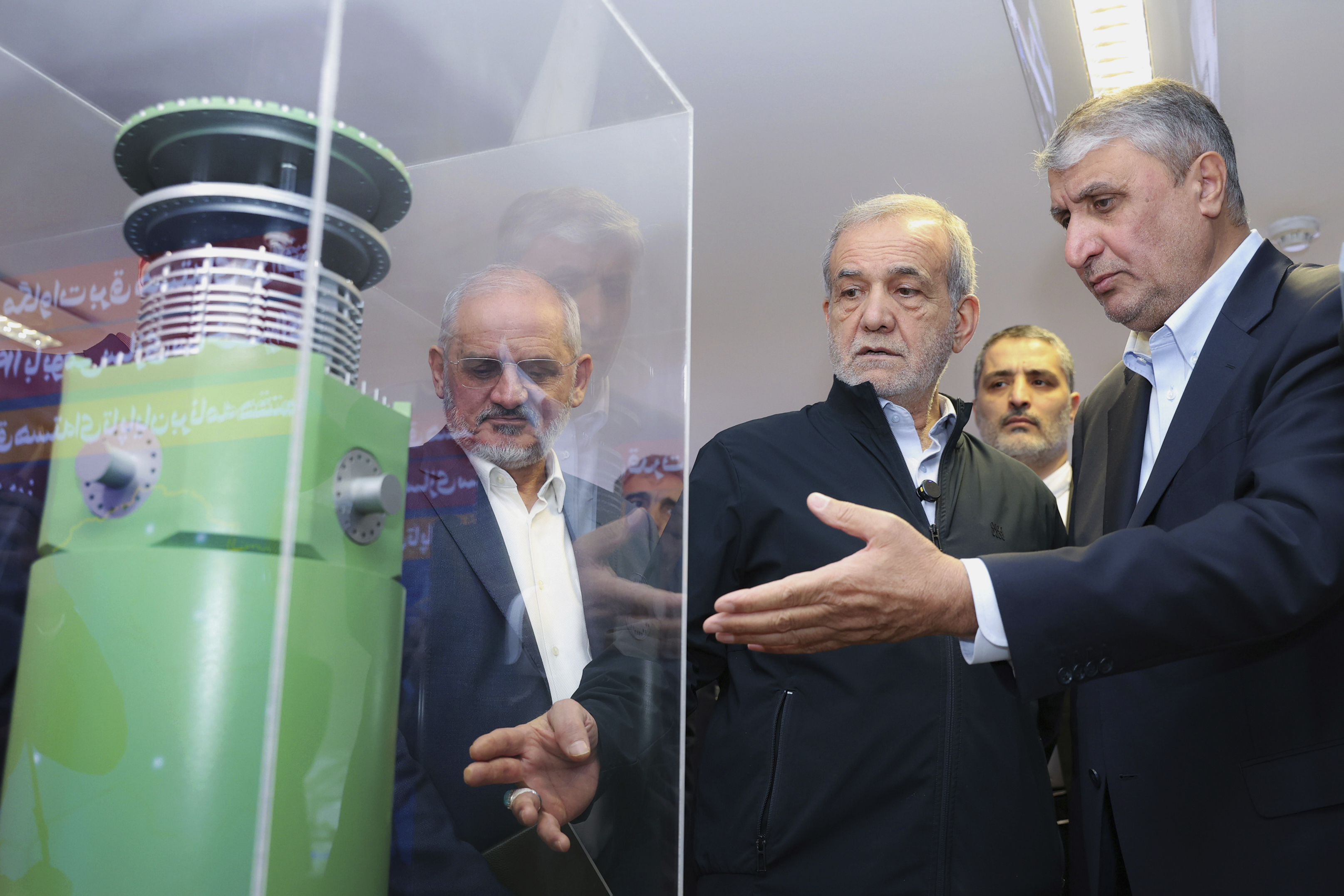 President Masoud Pezeshkian, second right, listens to head of Atomic Energy Organization of Iran Mohammad Eslami as he visits an exhibition of Iran's nuclear achievements in Tehran