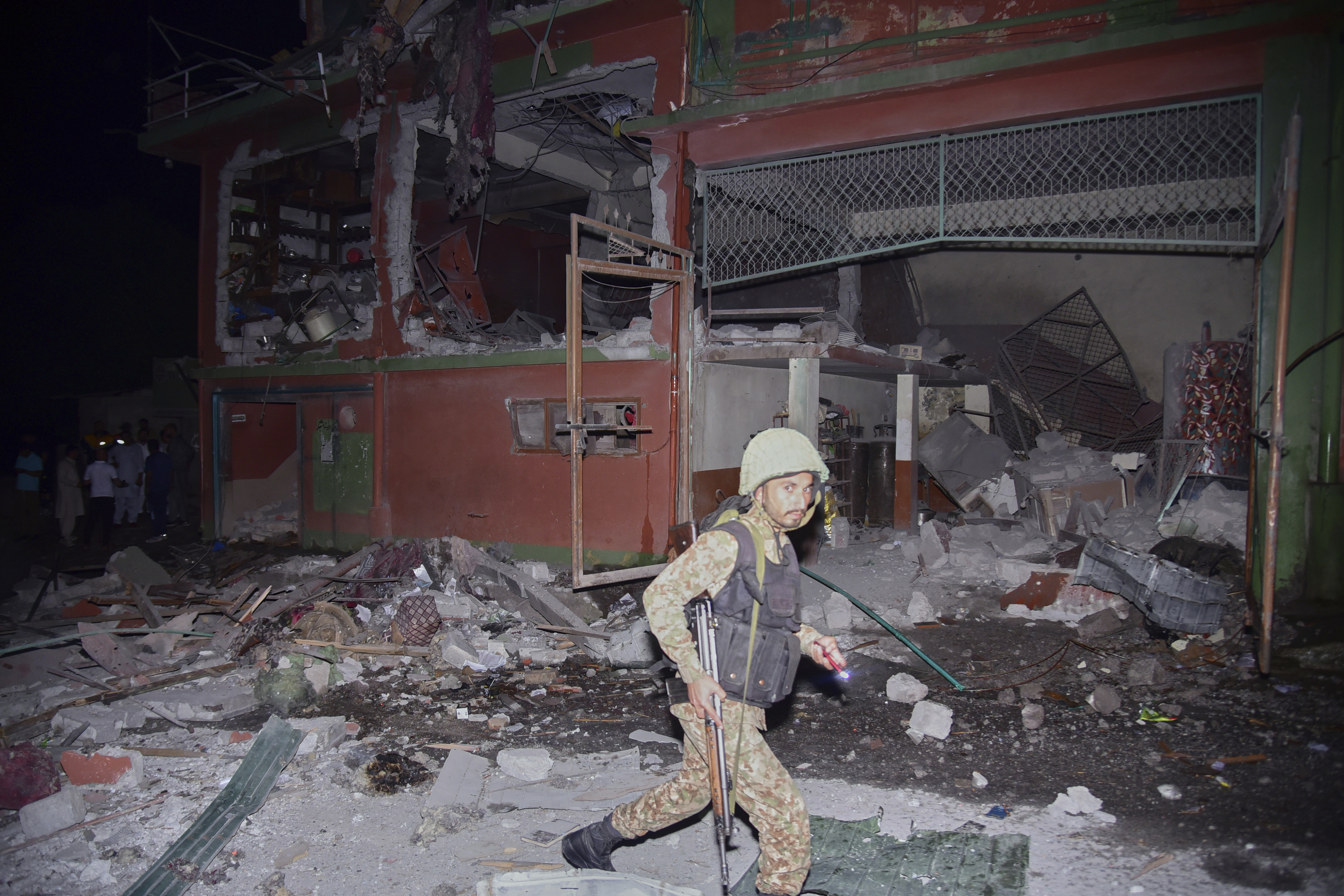 An army soldier examines a building damaged by a suspected Indian missile attack near Muzaffarabad, the capital of Pakistan controlled Kashmir, in Wednesday, May 7, 2025. (AP Photo/M.D. Mughal)
