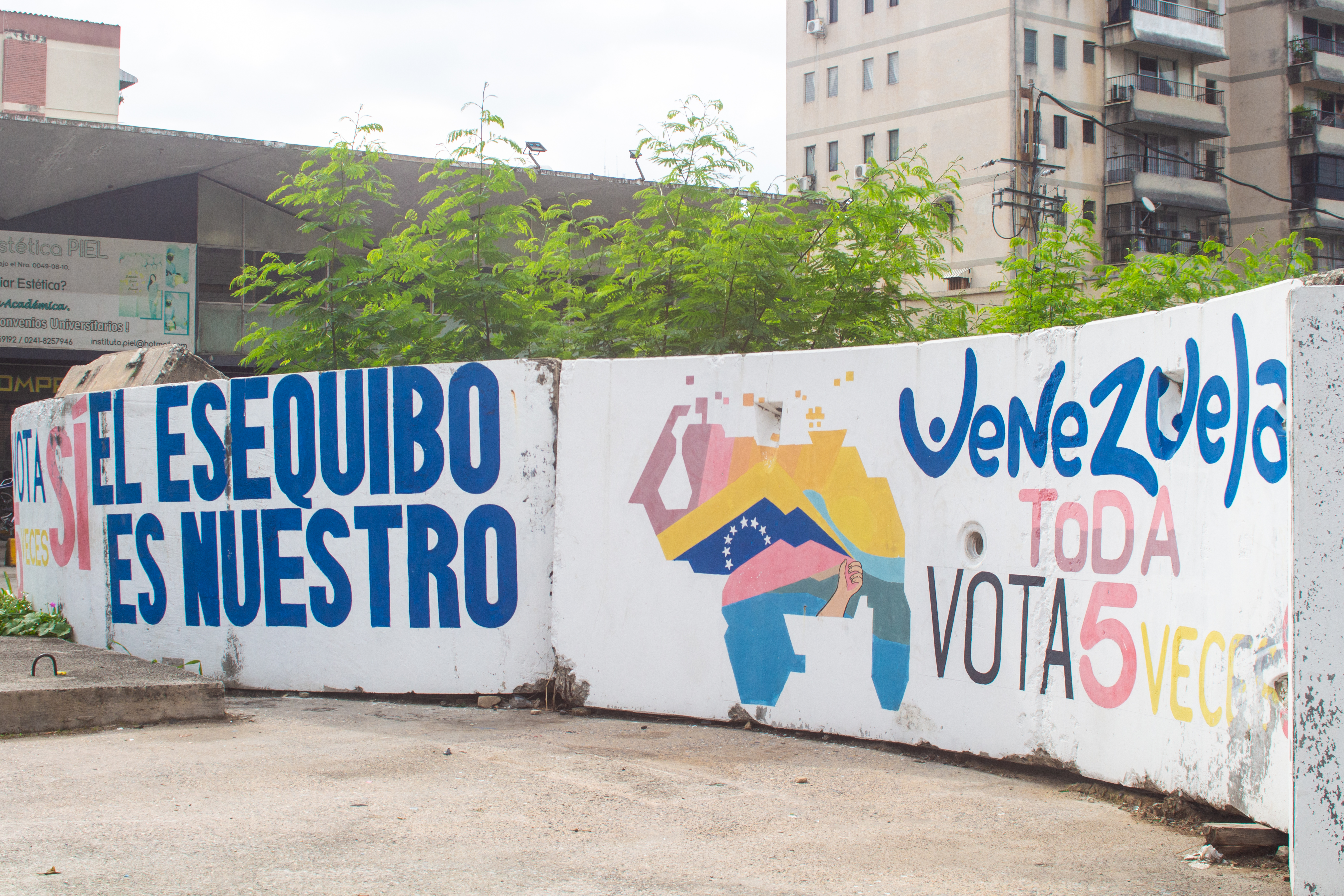A mural on an undulating wall reads, "Essequibo is ours."