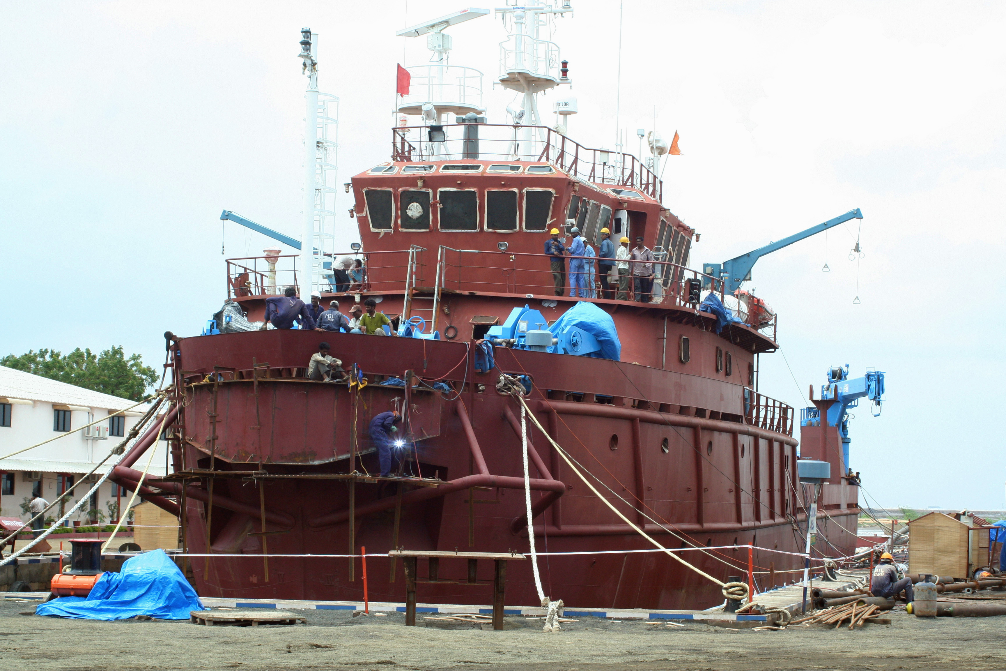 Employees work on a vessel at a ship building unit at Bhavnagar, about 180 km (112 miles) west from the western Indian city of Ahmedabad July 18, 2009. The unit has delivered four vessels of 7,500 tonnes to Italy and United Kingdom and has plans to expand up to 65,000 tonnes by the end of 2009, project and operations director Mehul Patel said on Saturday. REUTERS/Amit Dave (INDIA BUSINESS TRANSPORT)