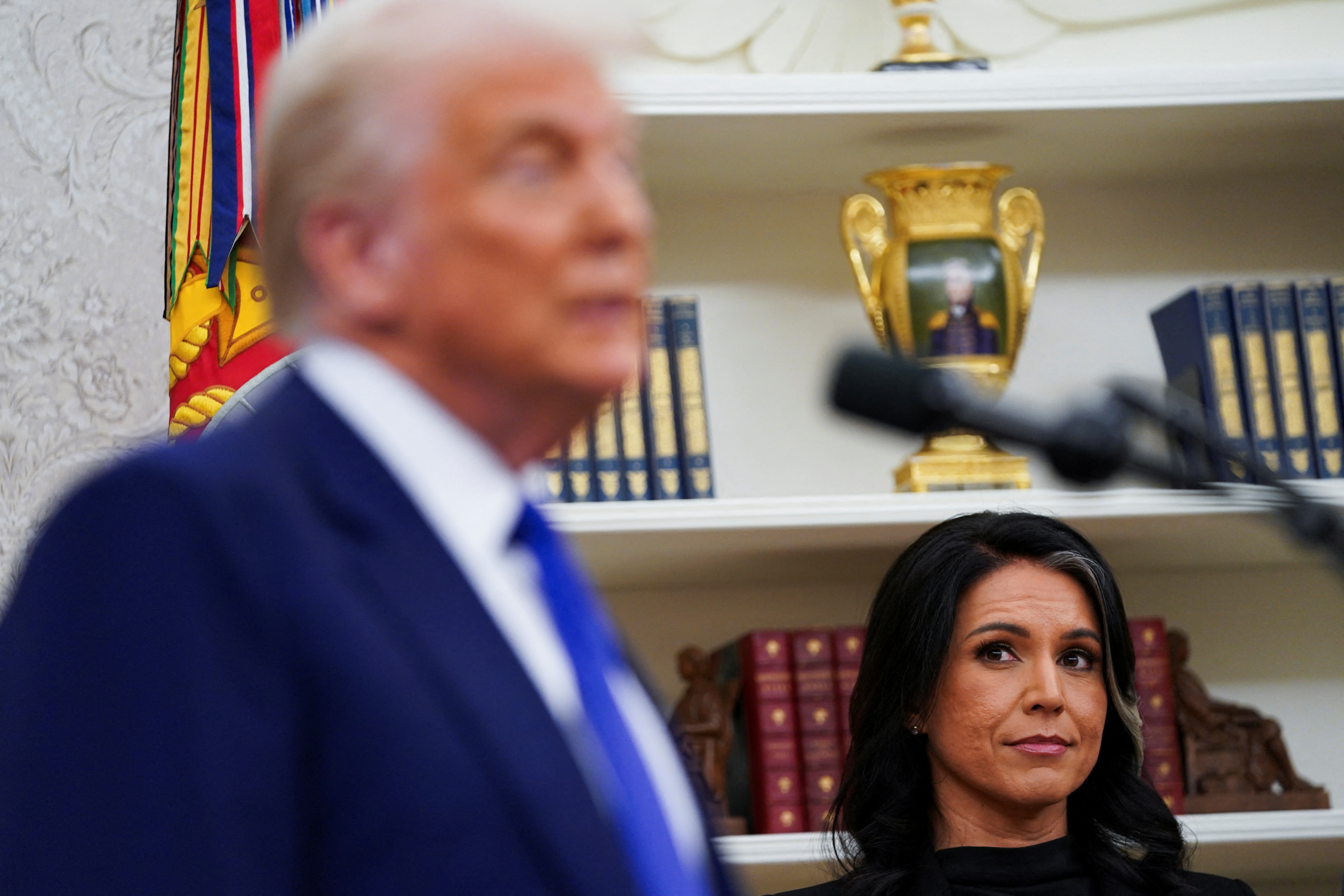 Tulsi Gabbard looks at U.S. President Donald Trump, on the day of her swearing in ceremony as Director of National Intelligence, in the Oval Office at the White House in Washington, D.C., U.S., February 12, 2025. REUTERS/Nathan Howard