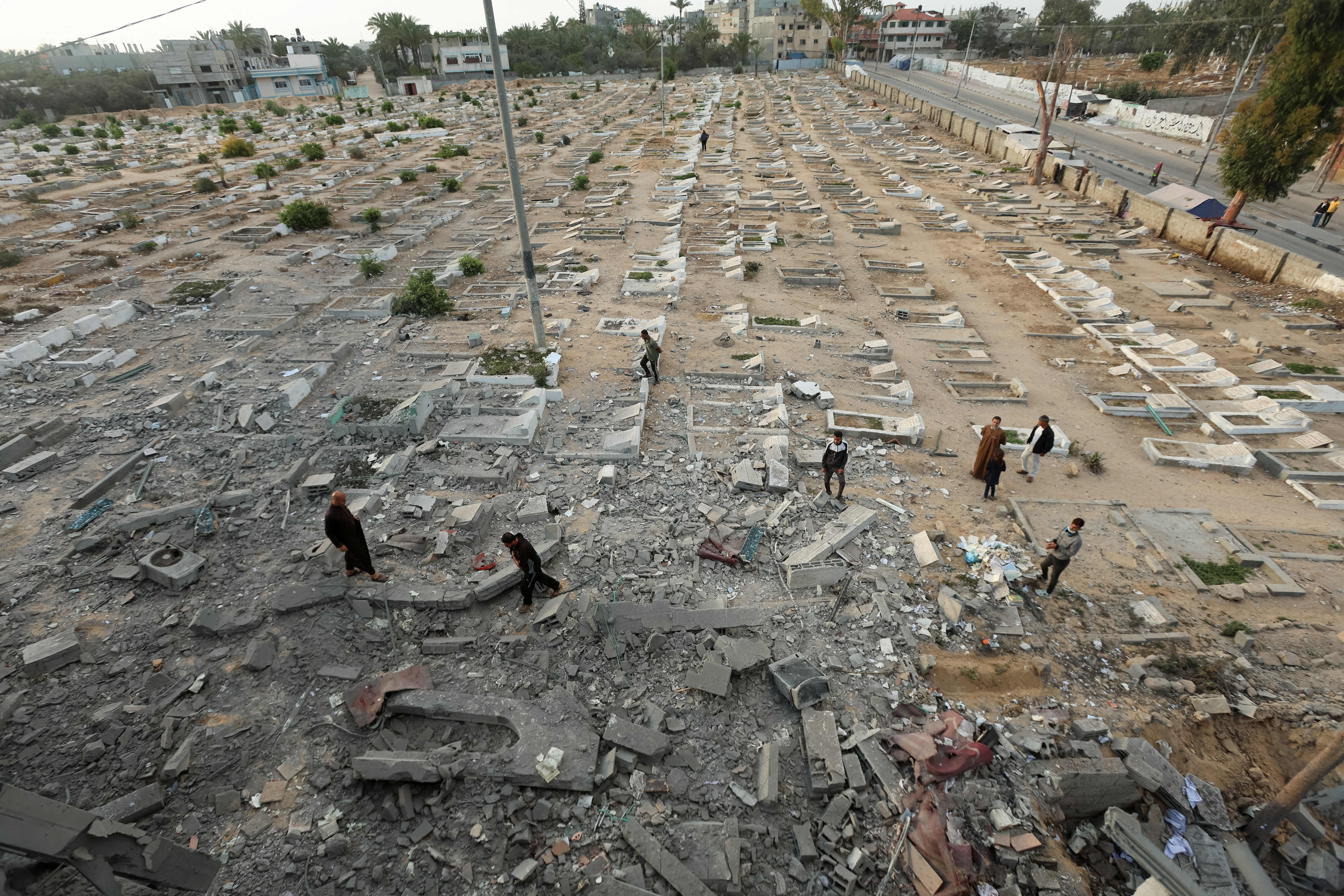 Palestinians inspect a cemetery damaged in Israeli shelling, in Deir Al-Balah, in the central Gaza Strip, June 2, 2025.