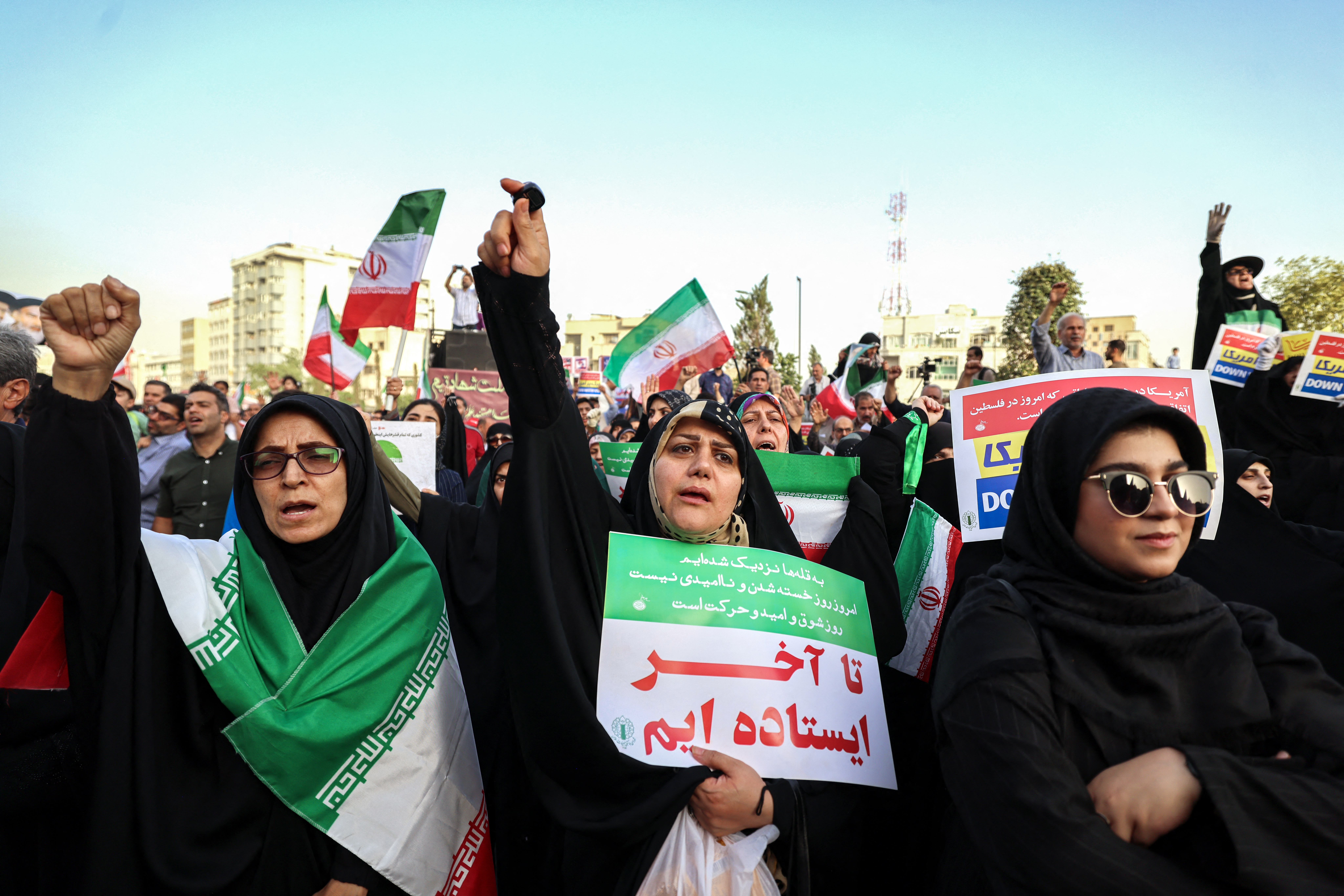 Iranians chant slogans and wave national flags as they celebrate a ceasefire between Iran and Israel at Enghlab Square in the capital Tehran on June 24, 2025