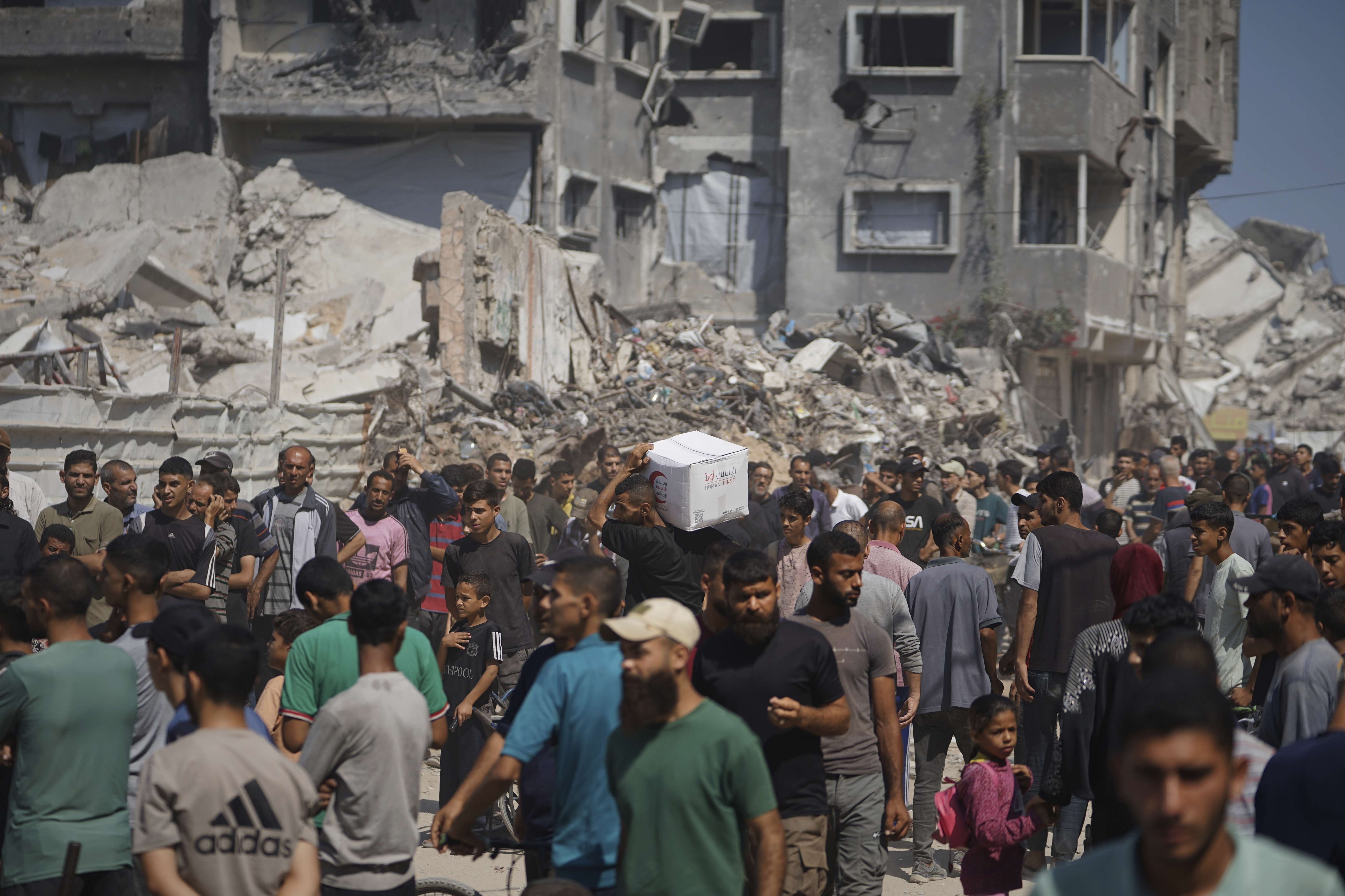 Palestinians receive food parcels at a distribution site.