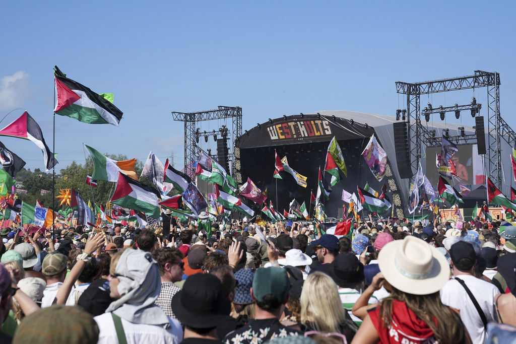 people hold palestinian flags at a music festival
