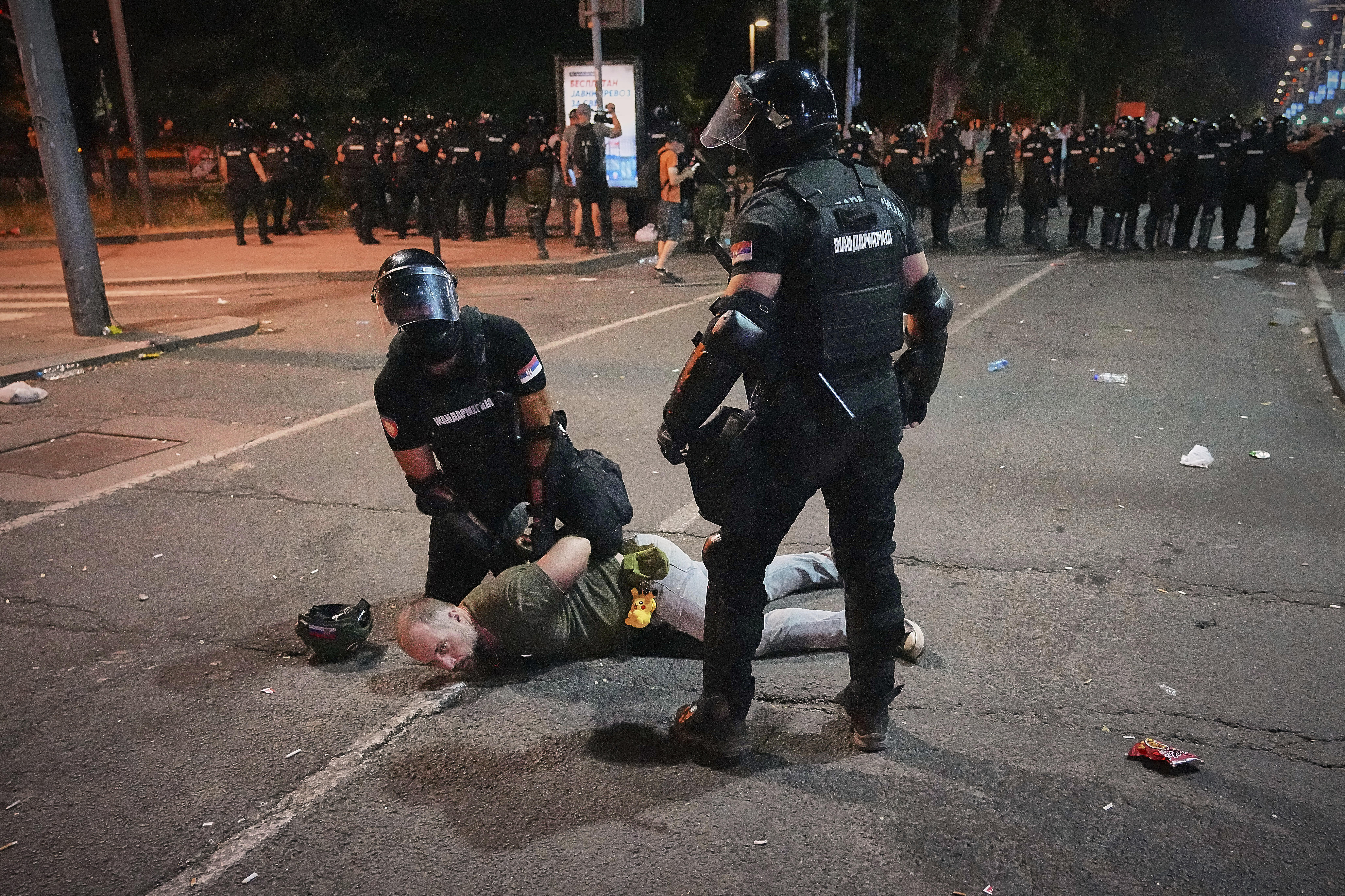 Riot police detain a man in Belgrade, Serbia