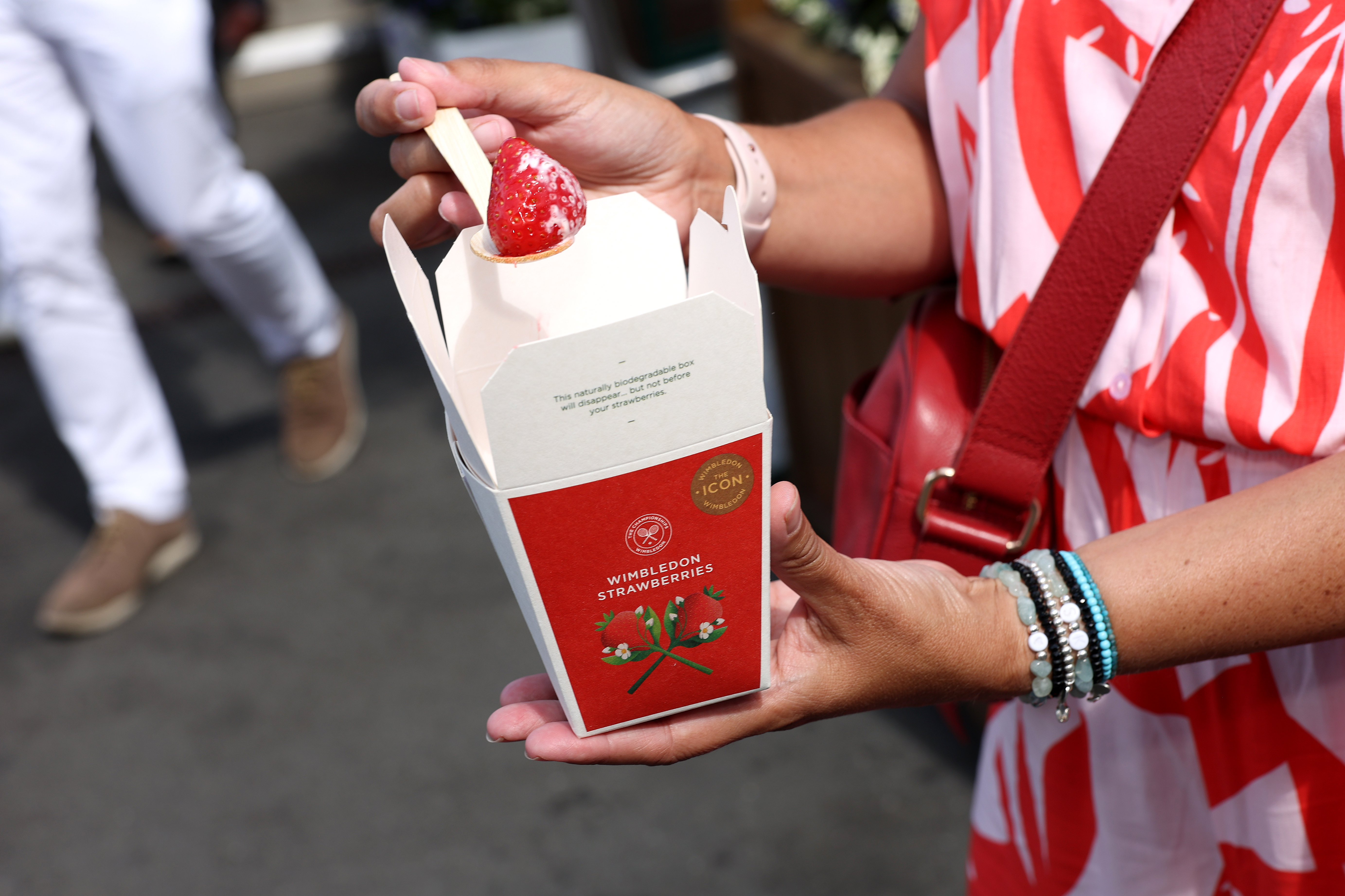 LONDON, ENGLAND - JULY 04: A spectator enjoys strawberries and cream during day four of The Championships Wimbledon 2024 at All England Lawn Tennis and Croquet Club on July 04, 2024 in London, England. (Photo by Julian Finney/Getty Images)