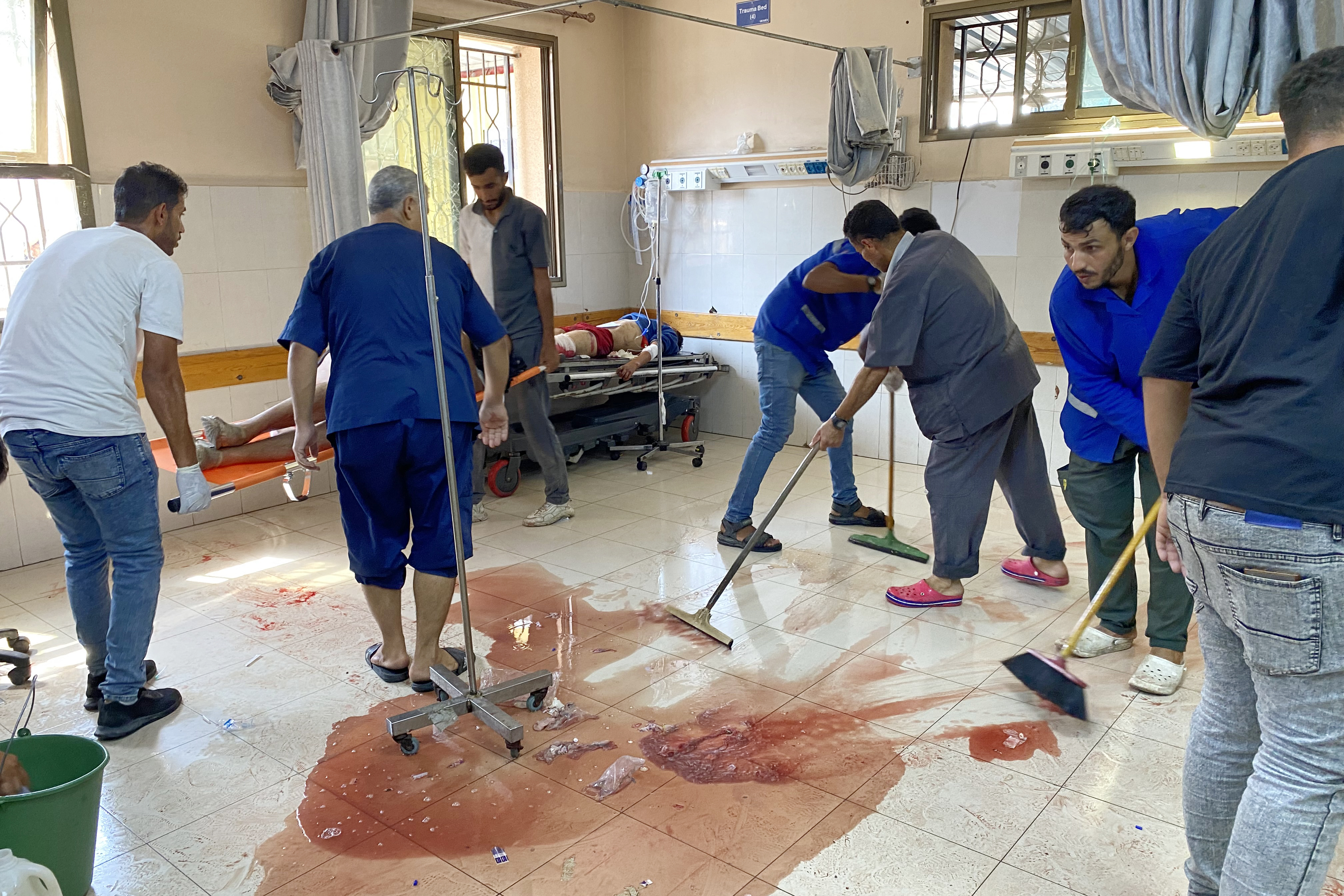 Medics clean the floor of blood as others care for injured Palestinians in a hospital.