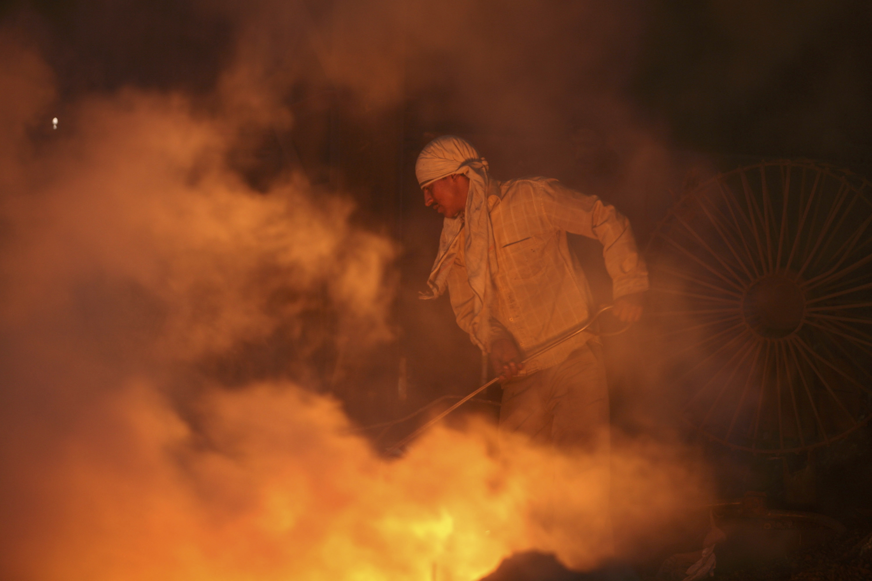 A labourer works inside a steel factory on the outskirts of Jammu, India