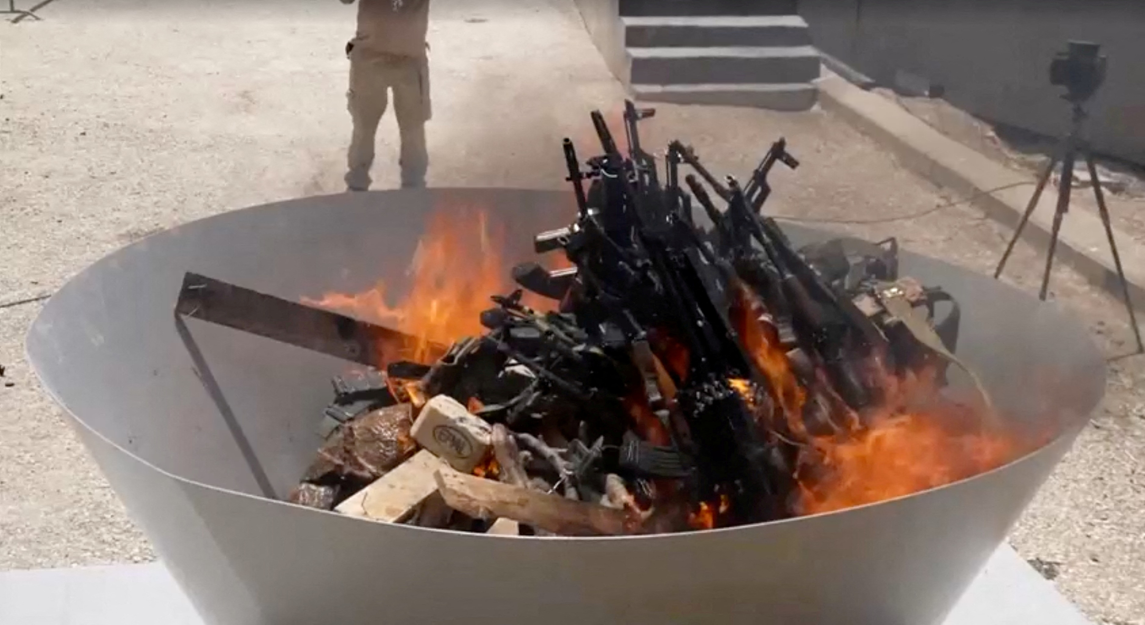 PKK fighters burn weapons during disarming ceremony.