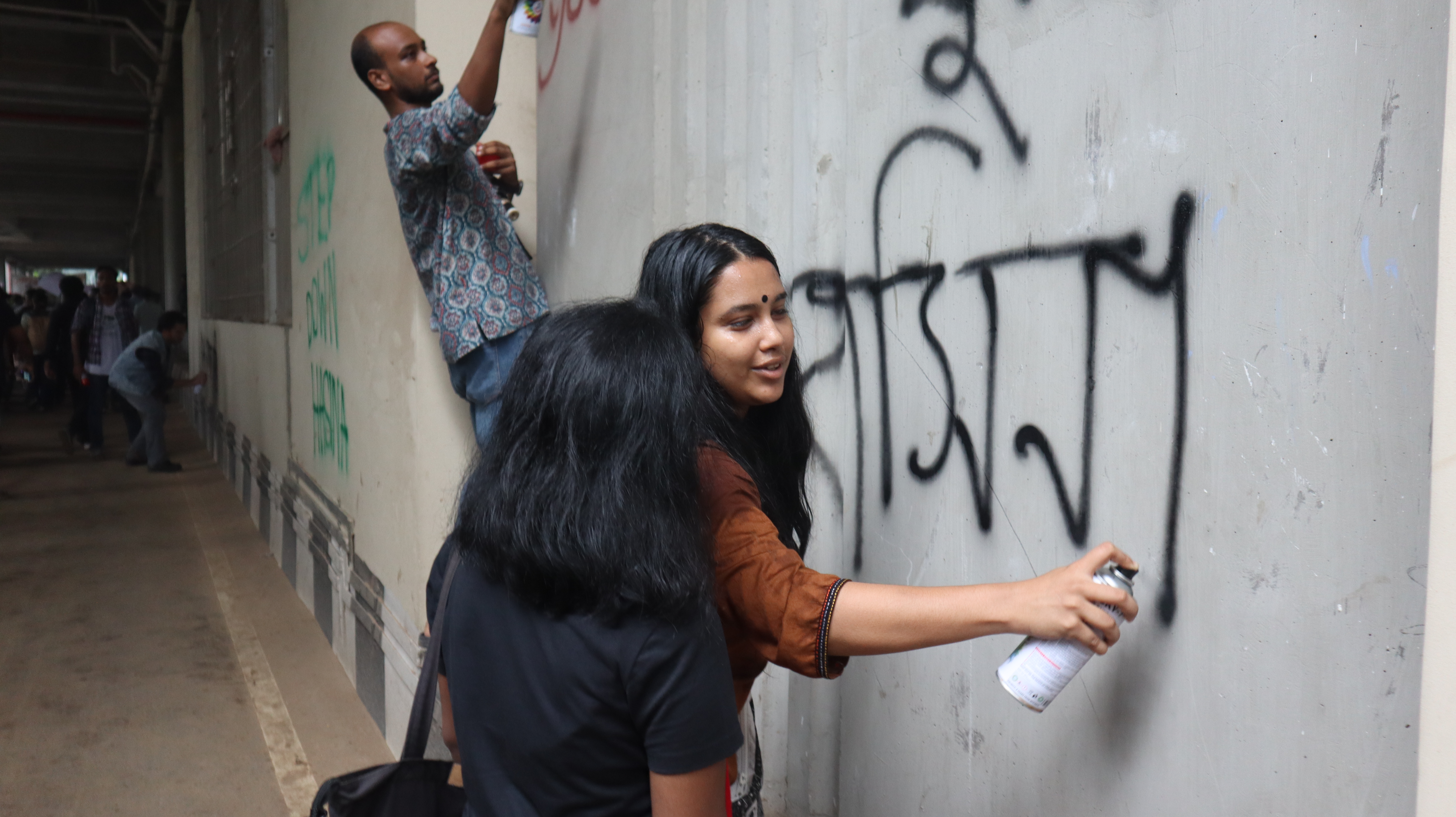Protesters drawing graffiti, writing slogans against Sheikh Hasina on the walls of Dhaka [Masum Billah/Al Jazeera]